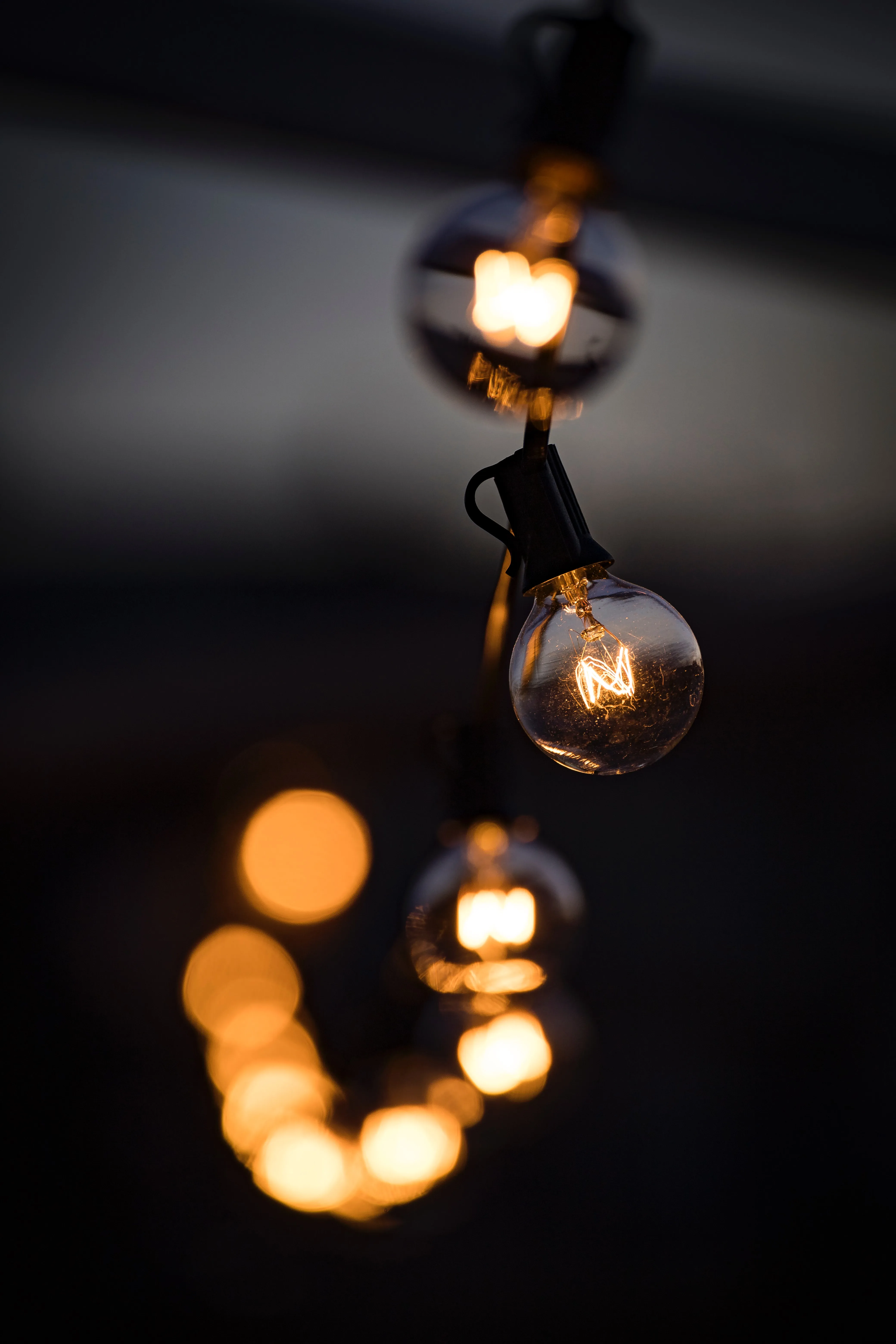 Hanging Light Bulbs Glowing in the Dark Wallpaper