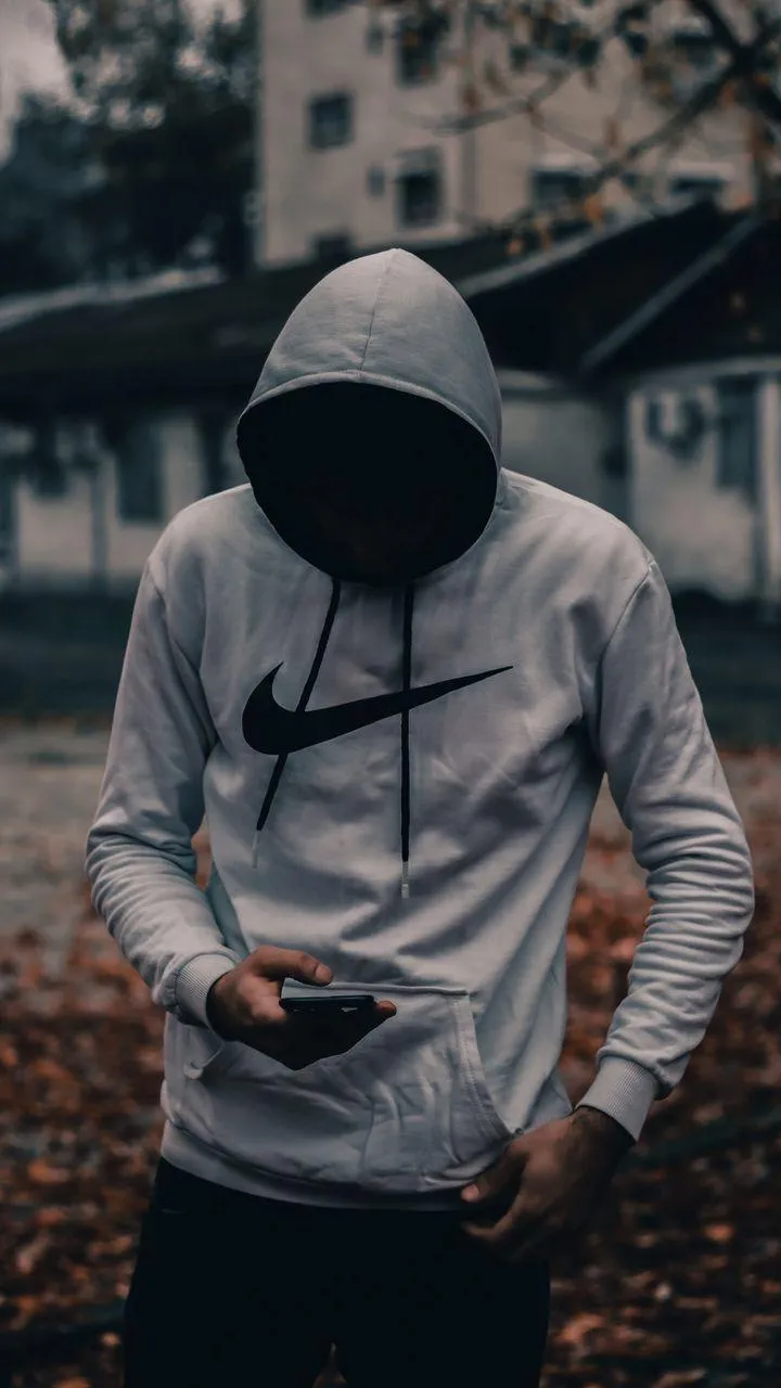 Hooded Figure Standing in Autumn Urban Setting Wallpaper