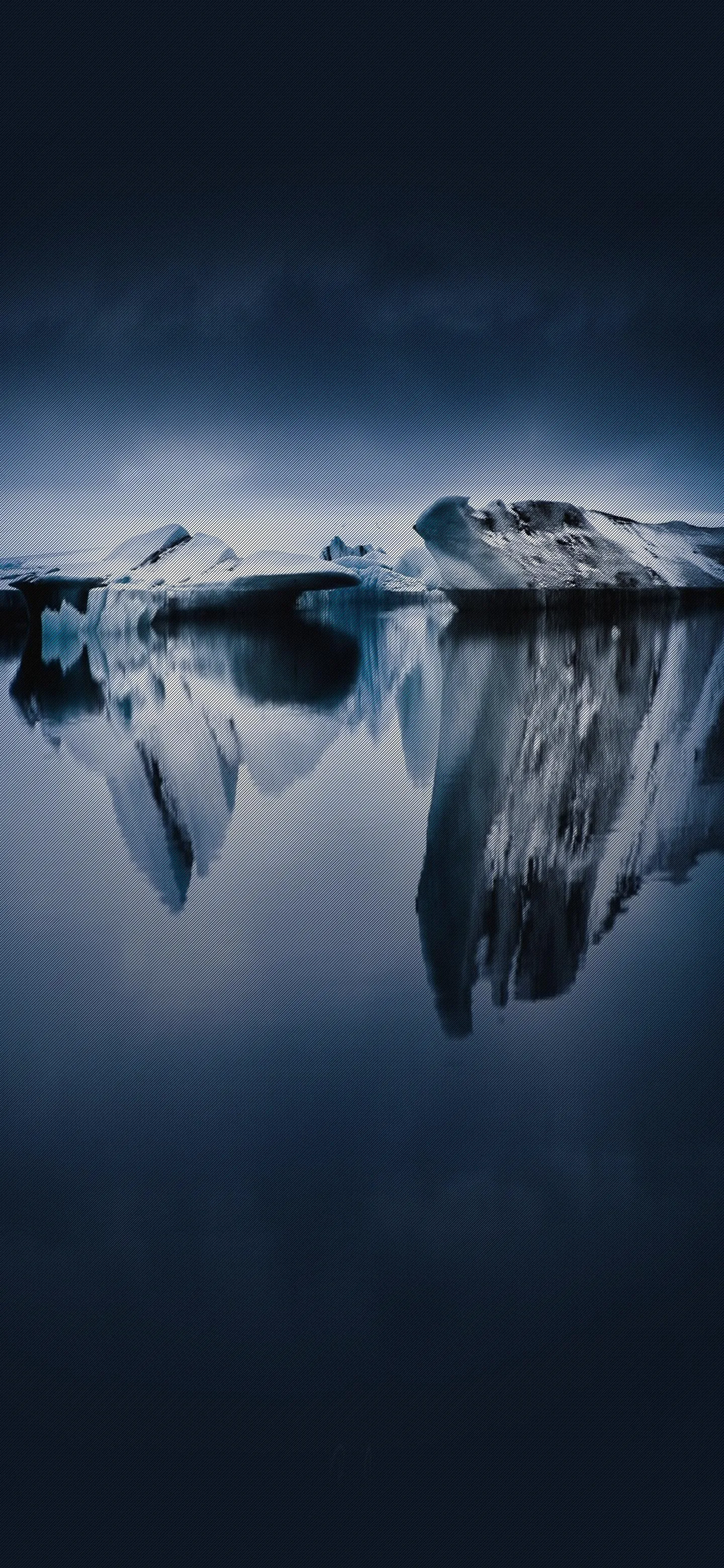 Iceberg Reflection on Calm Blue Water Under Clear Sky