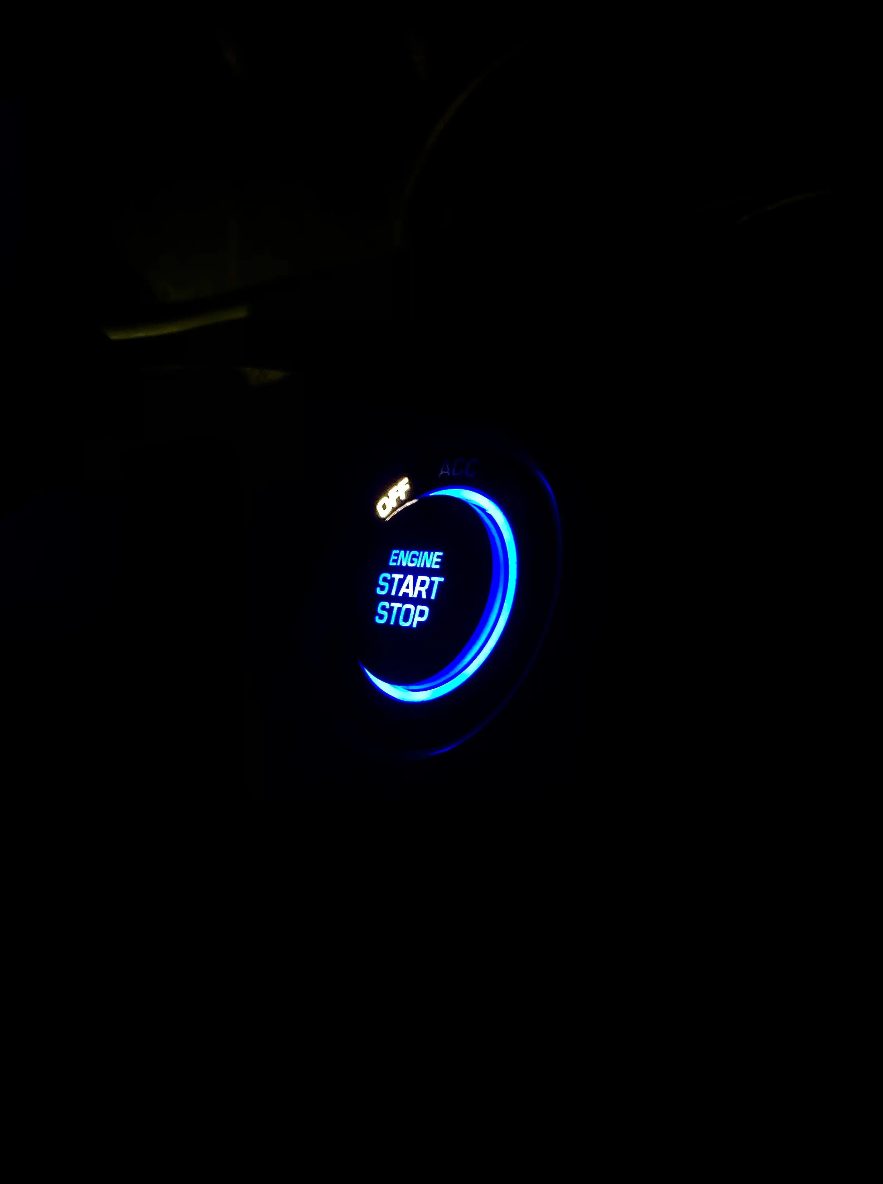 Illuminated Car Engine Start Stop Button Glowing at Night