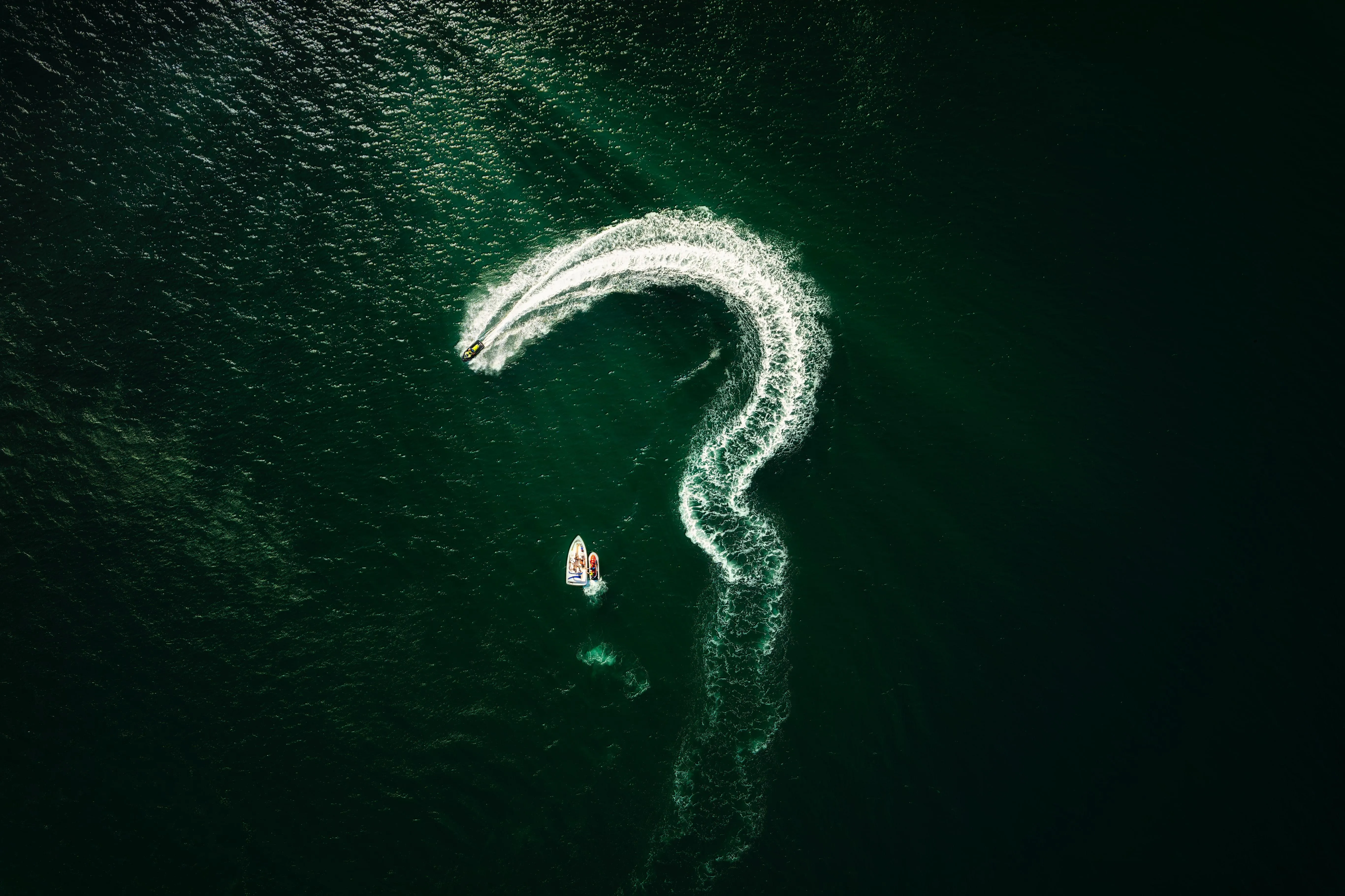 Jet Ski Leaves Question Mark Trail on Deep Green Water