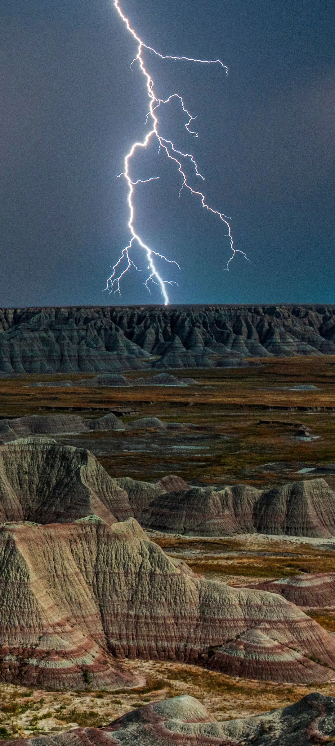 Lightning Storm Over Colorful Layered Desert Rocks Image