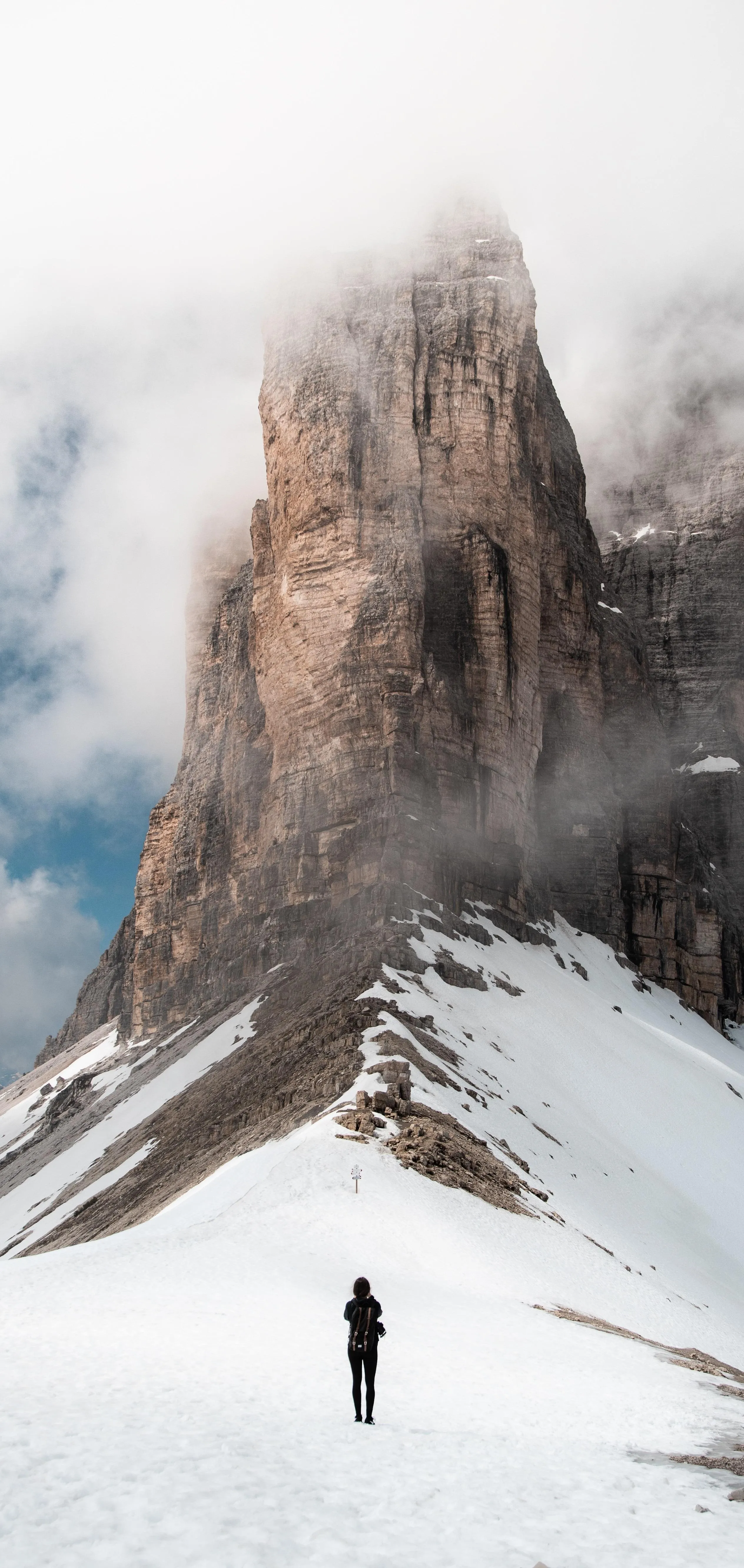 Lone Hiker Walking Toward Towering Snowy Mountain Peaks