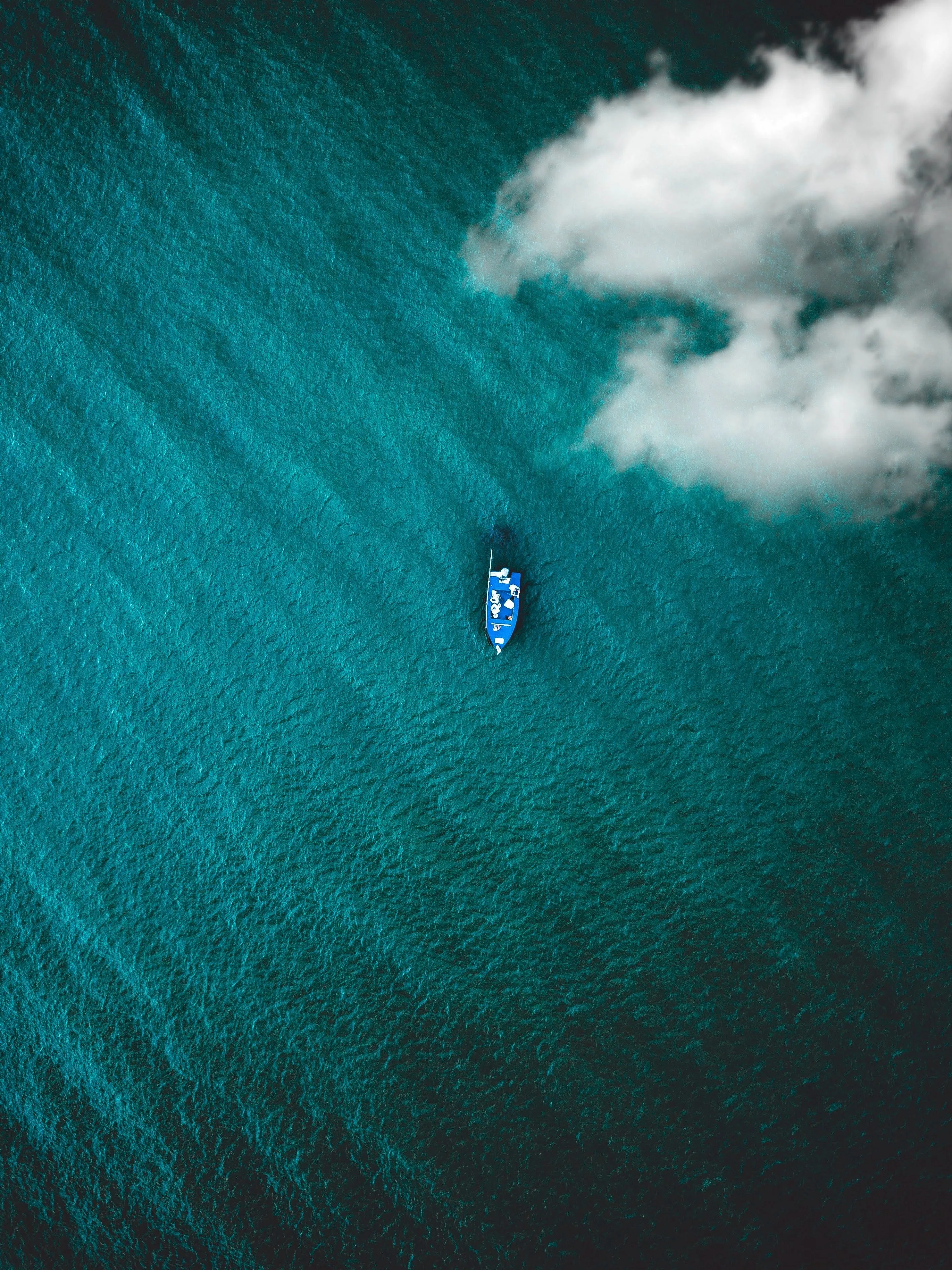 Lonely Boat Floating in Vast Calm Ocean Top View Wallpaper