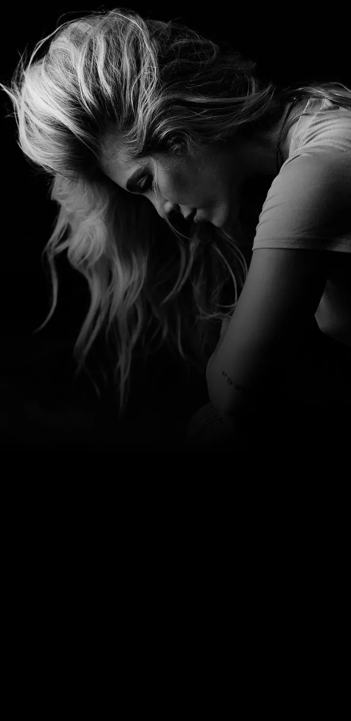 Lonely Woman in Shadows Depicting Deep Emotions Wallpaper