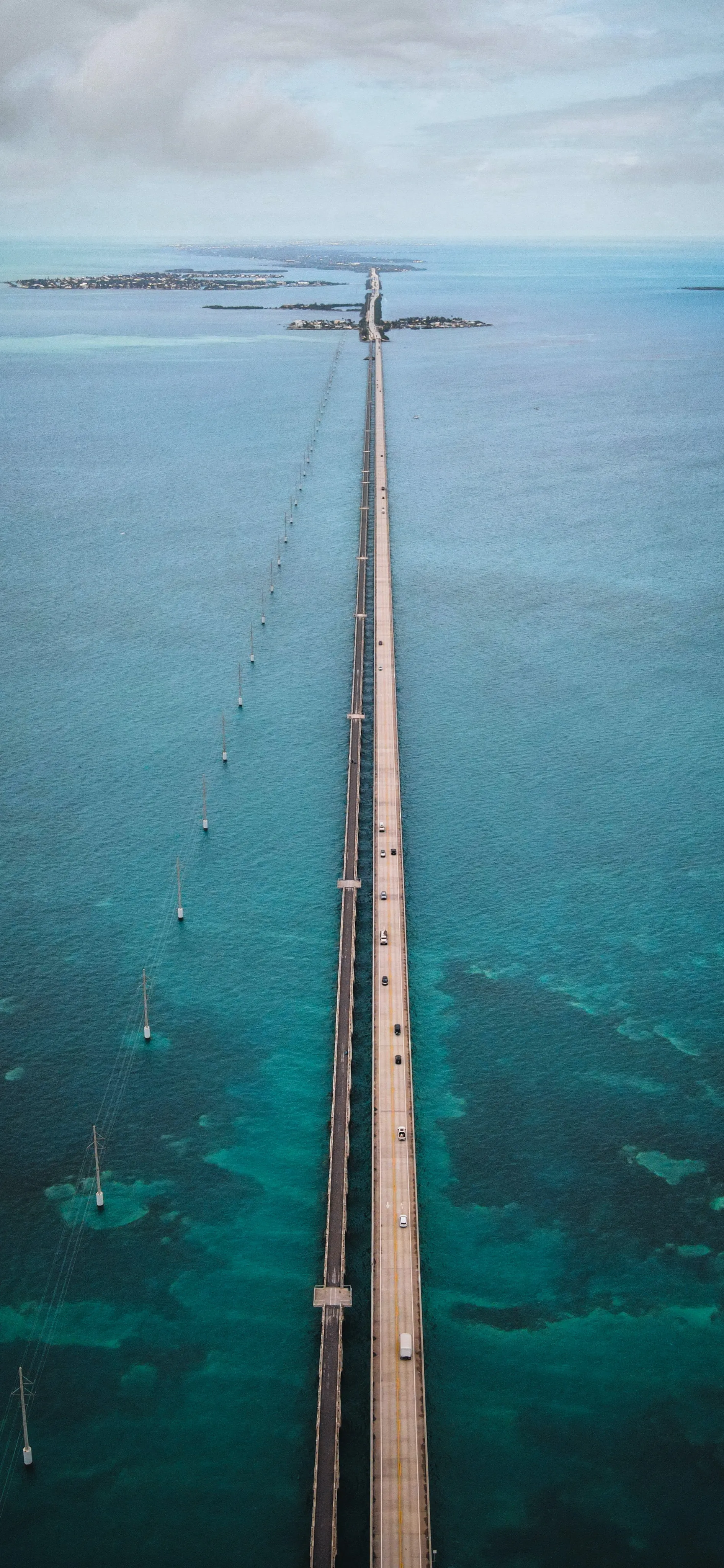 Long Pier Extending into Clear Blue Ocean Under Calm Weather