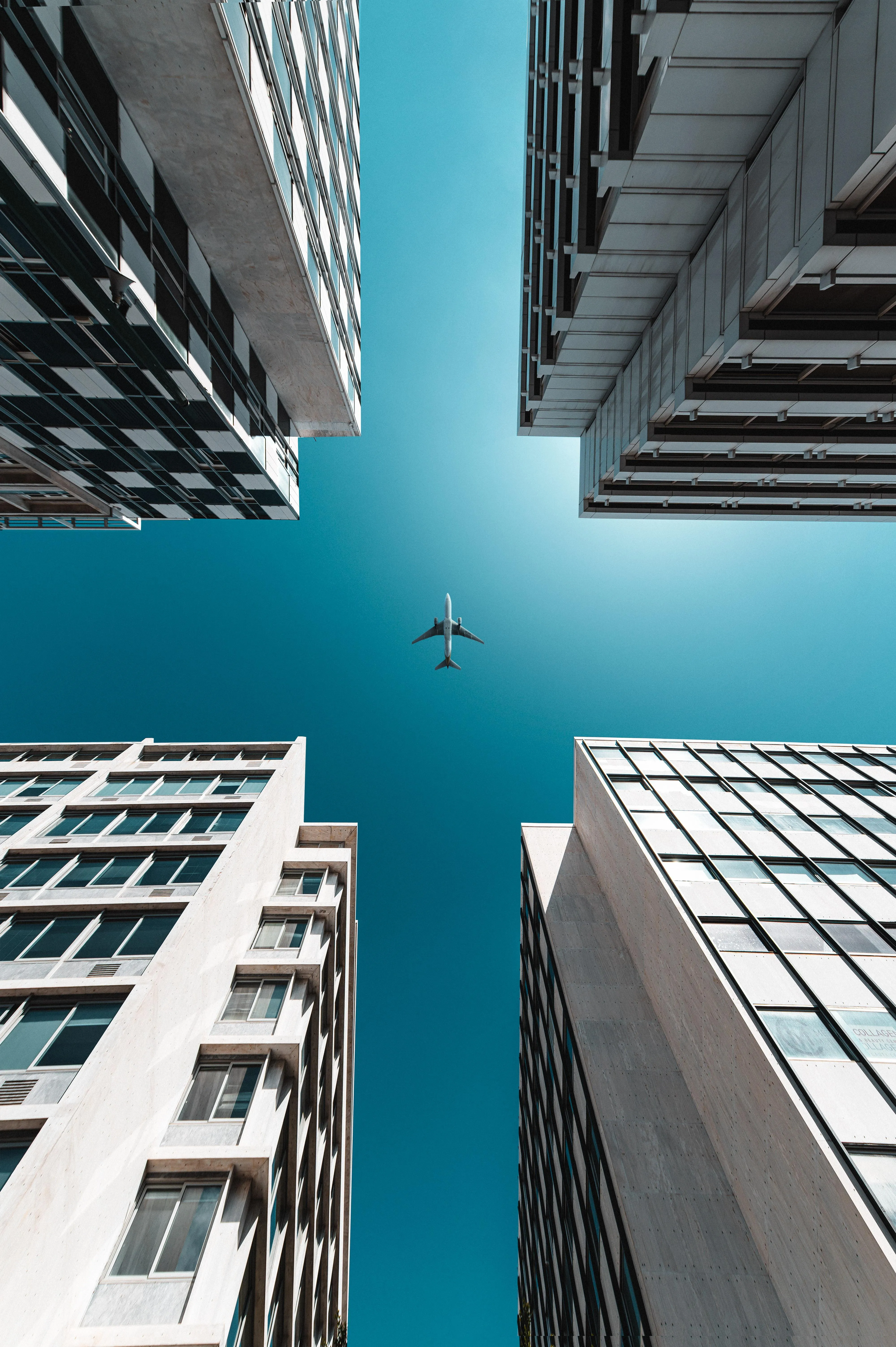Looking Up Between Tall Buildings with Airplane Flying High