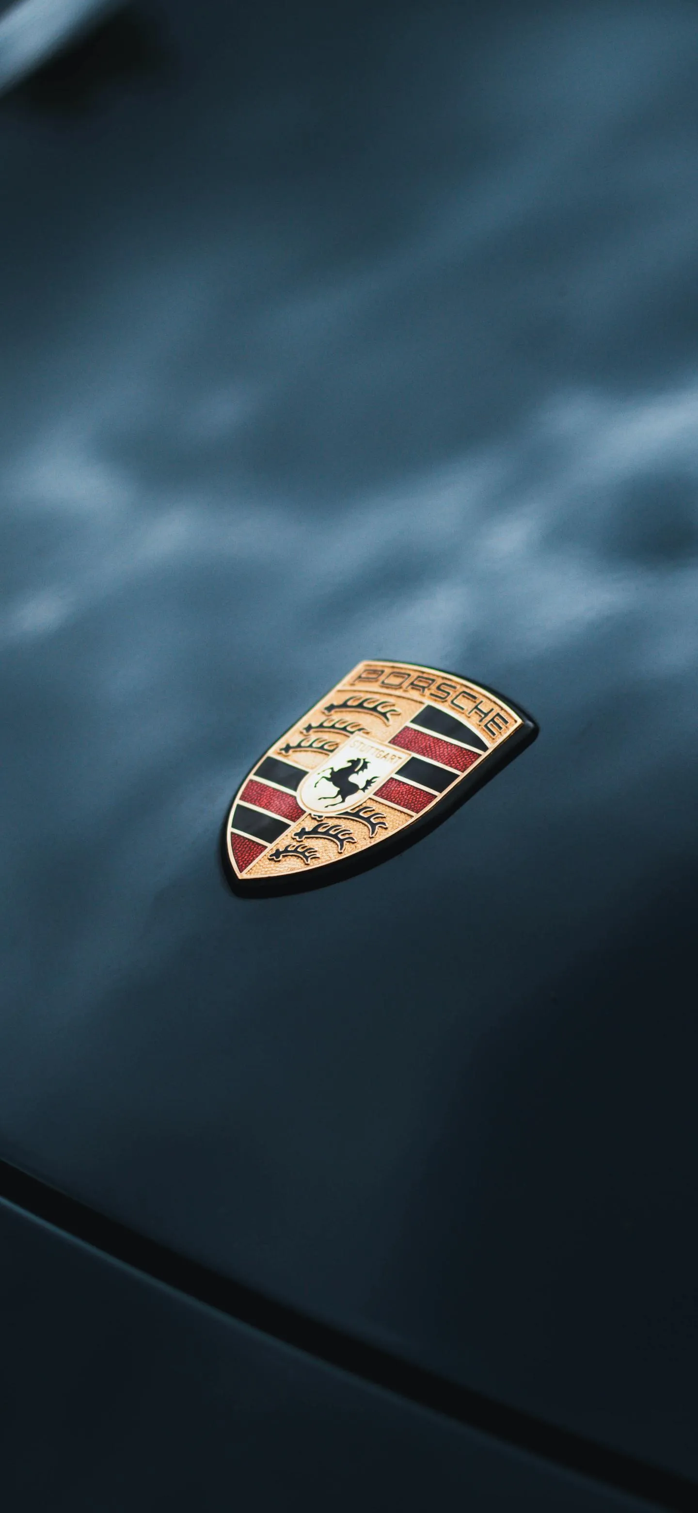Luxury Porsche Logo Close Up on Car Hood Wallpaper Image