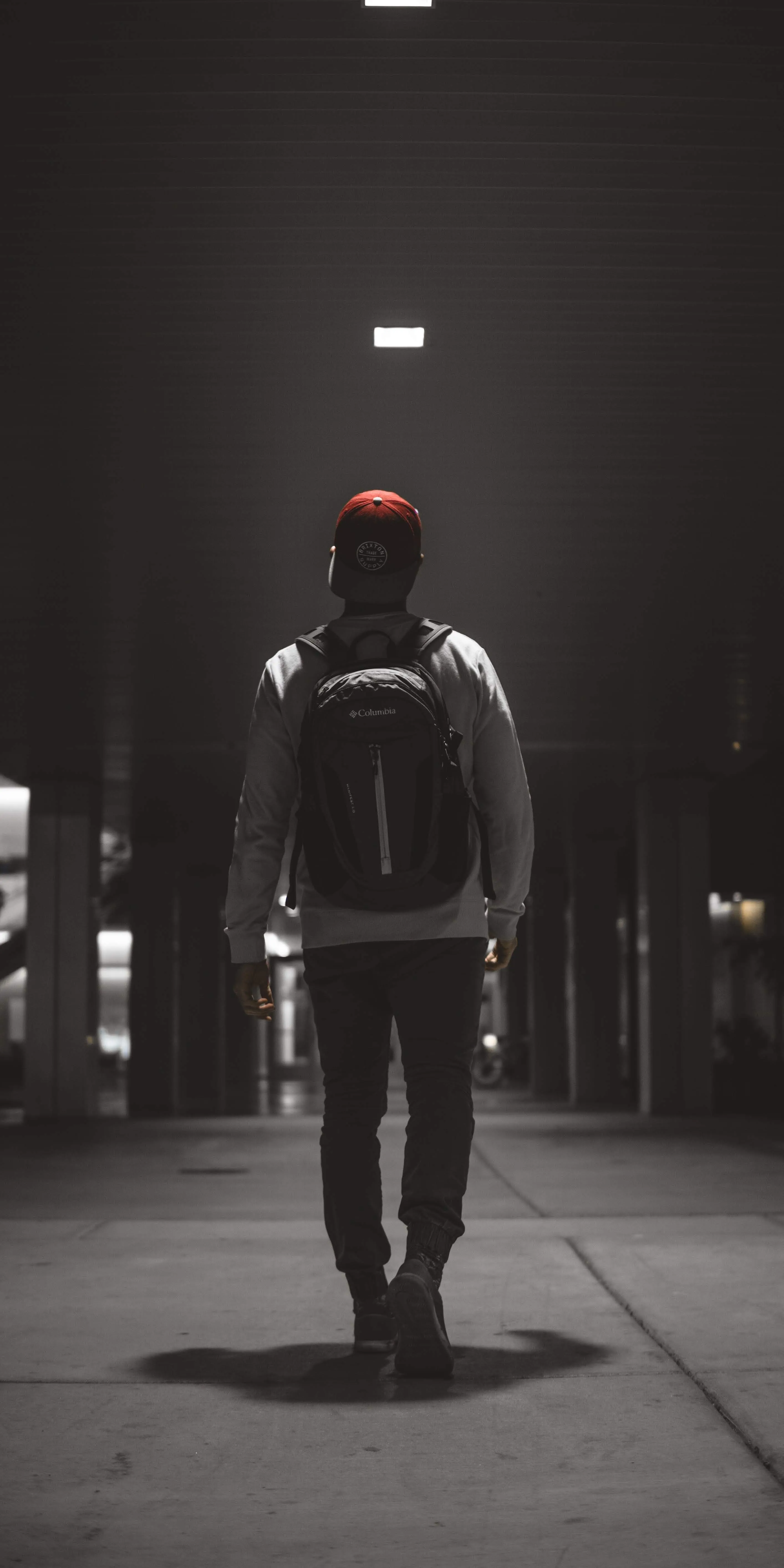 Man Walking Alone in Dark Street Under Lamp Light Wallpaper