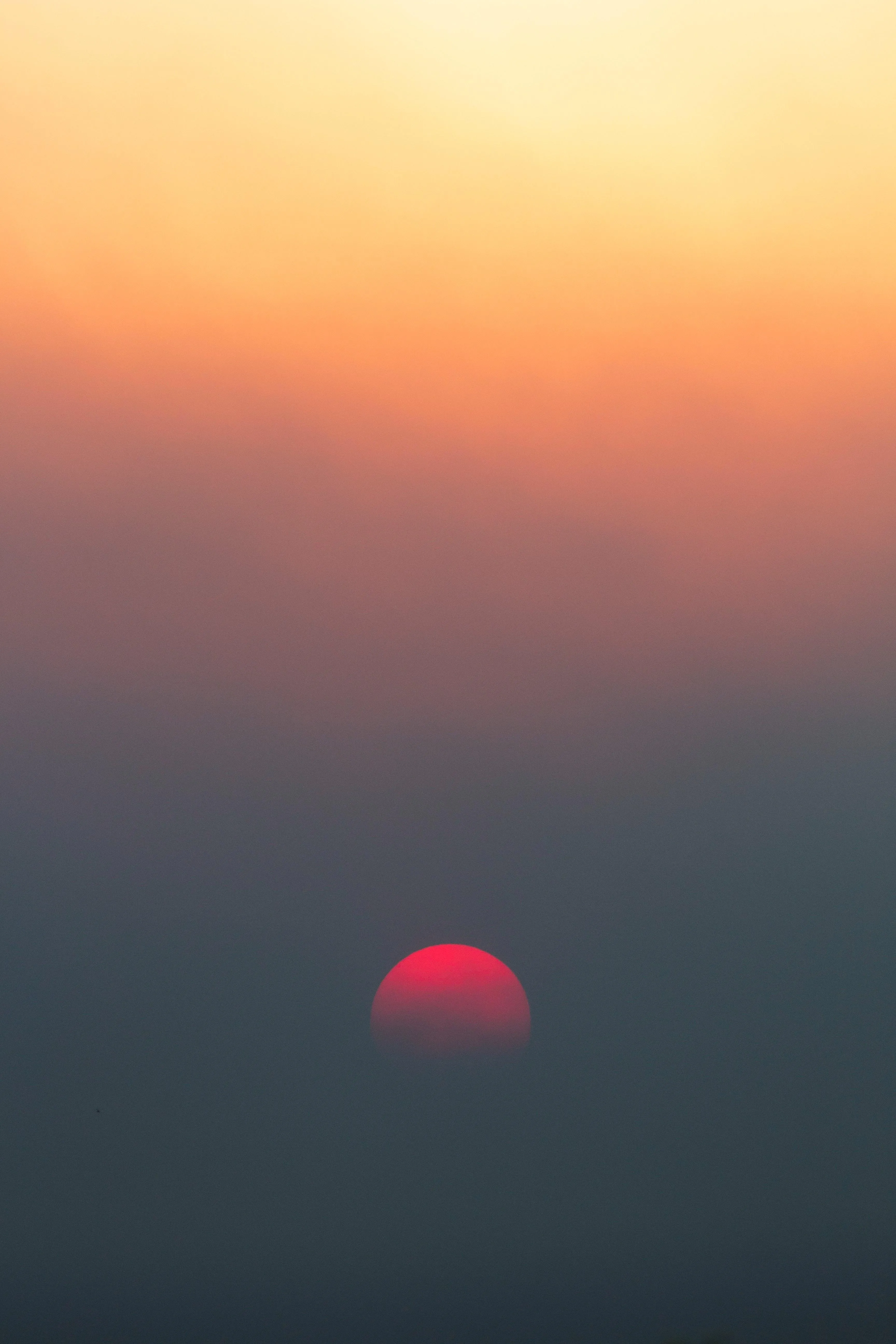 Minimalist View of Red Sun Setting in Orange Dusk Sky