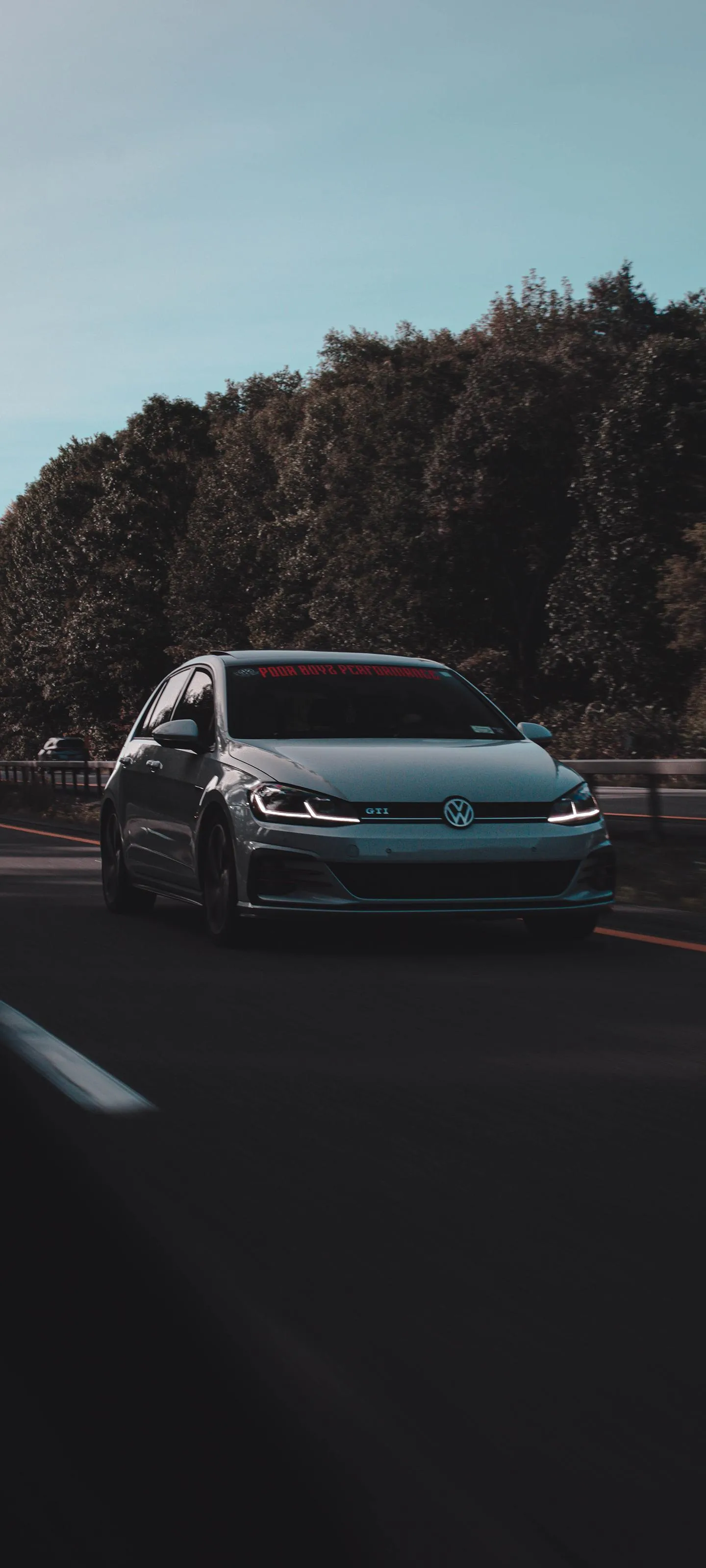 Modern Car Driving on a Forest Road in Early Morning