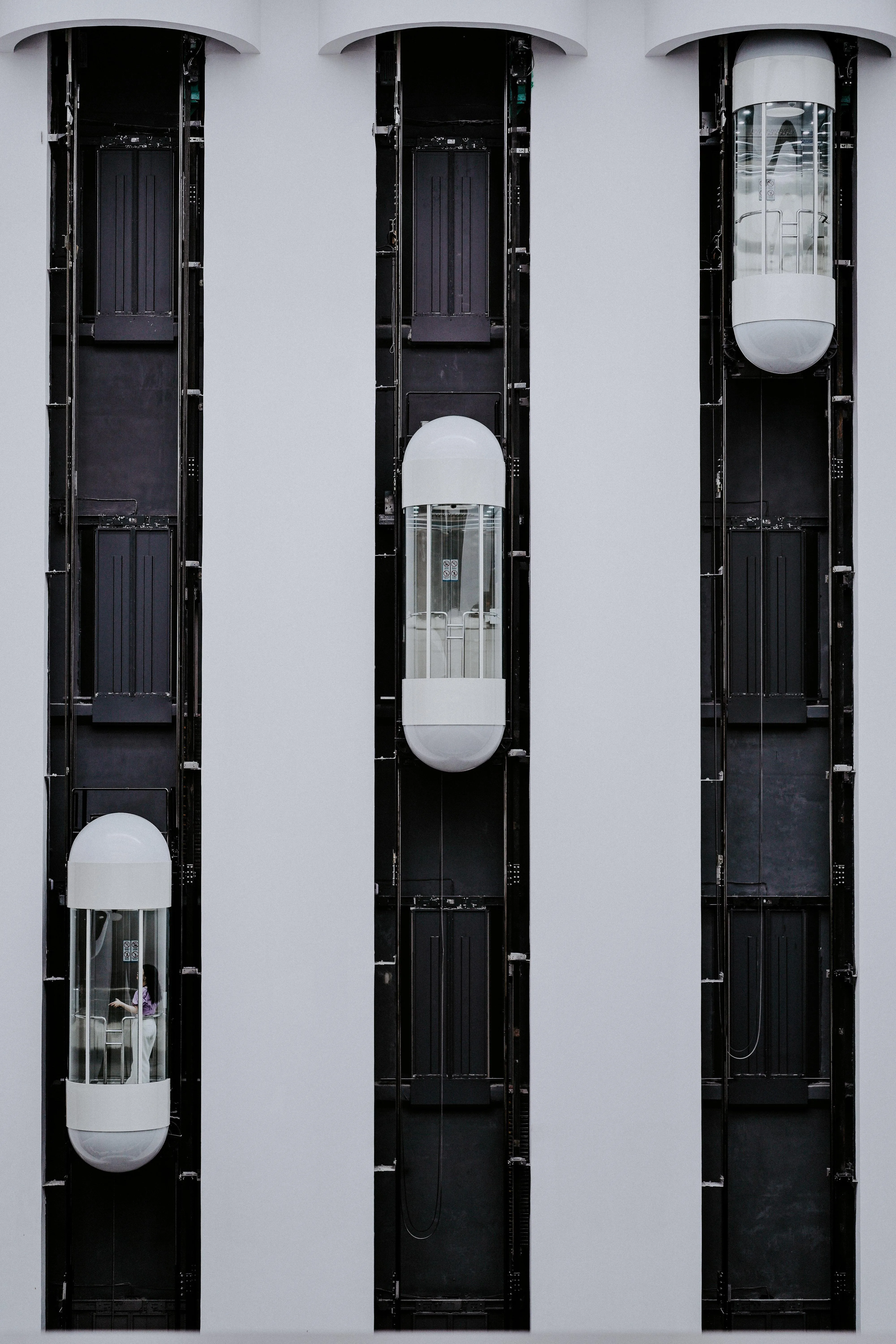 Modern Glass Elevators on Vertical Black Shaft System Image
