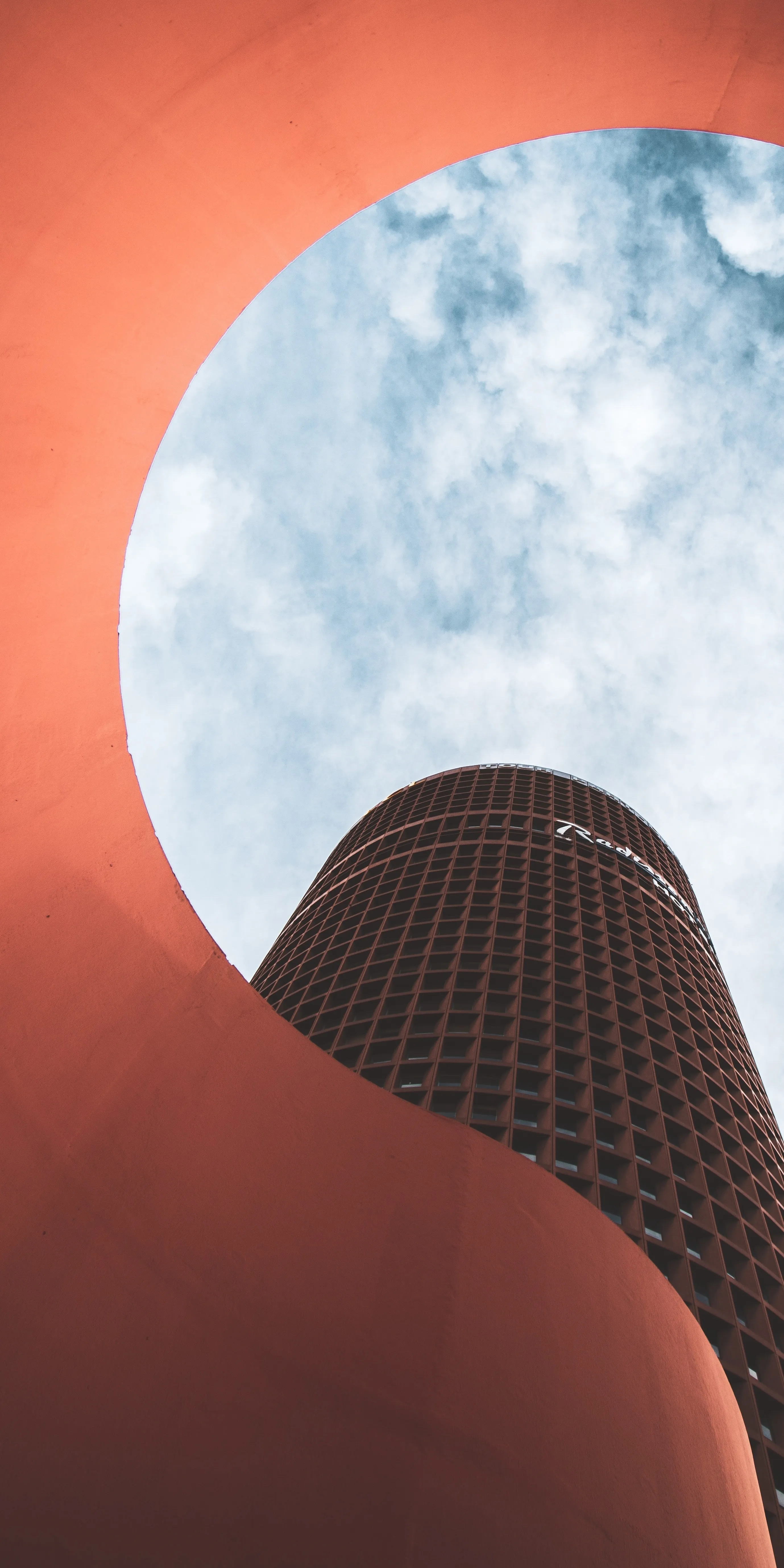 Modern Skyscraper Viewed Through Circular Orange Frame