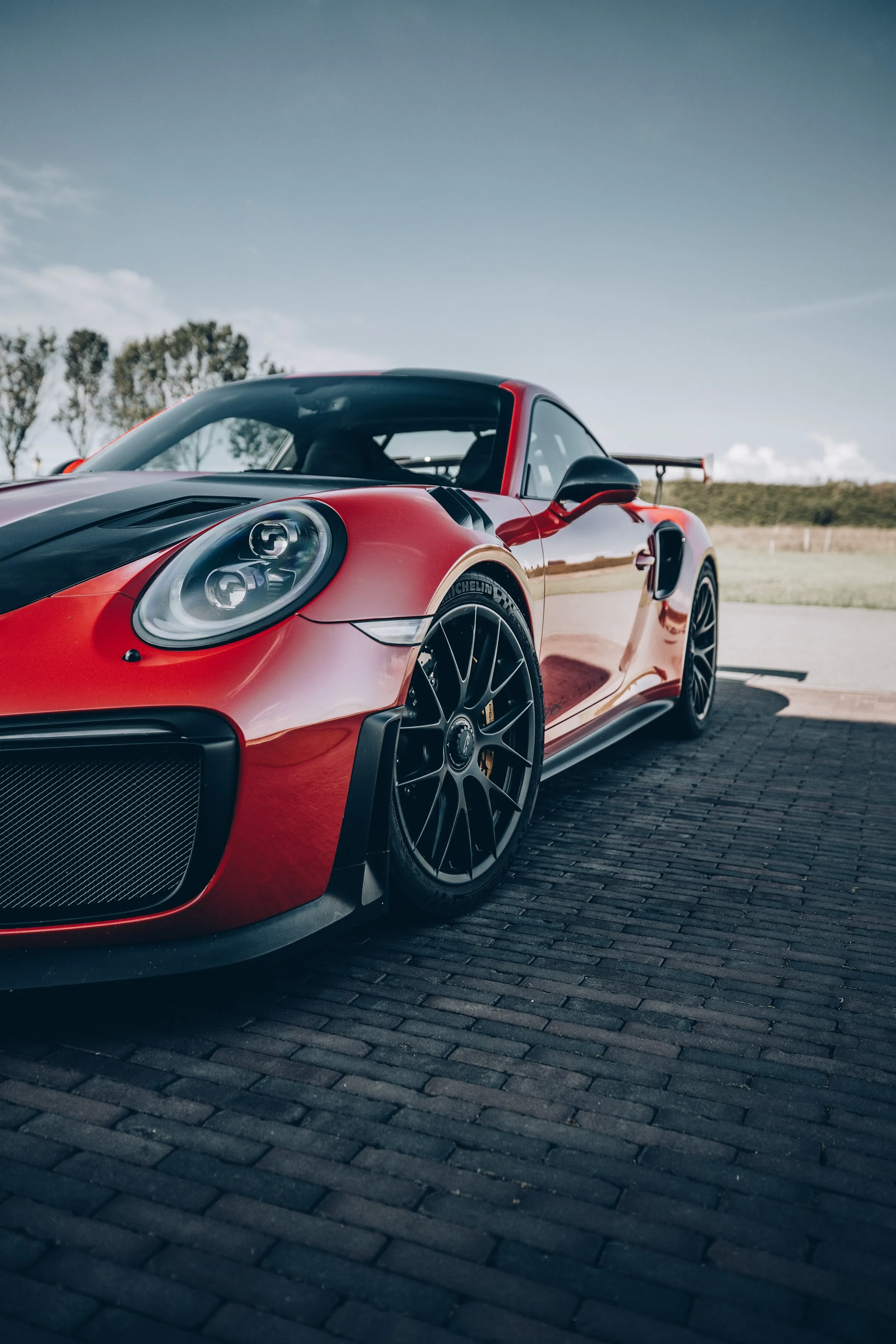 Modern Sports Car on Roadside Under Clear Sky Wallpaper