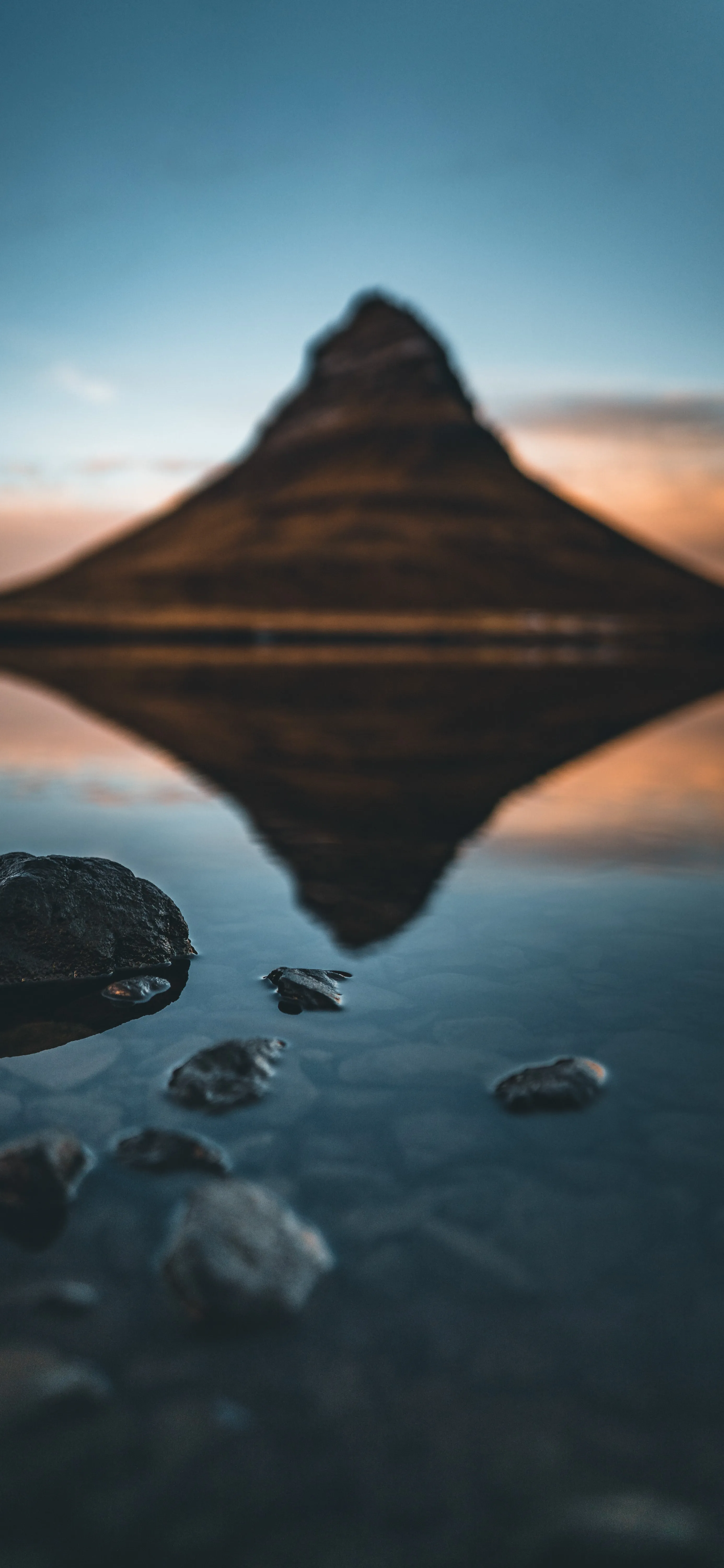 Mountain Reflection in Crystal Clear Lake with Rocky Shore