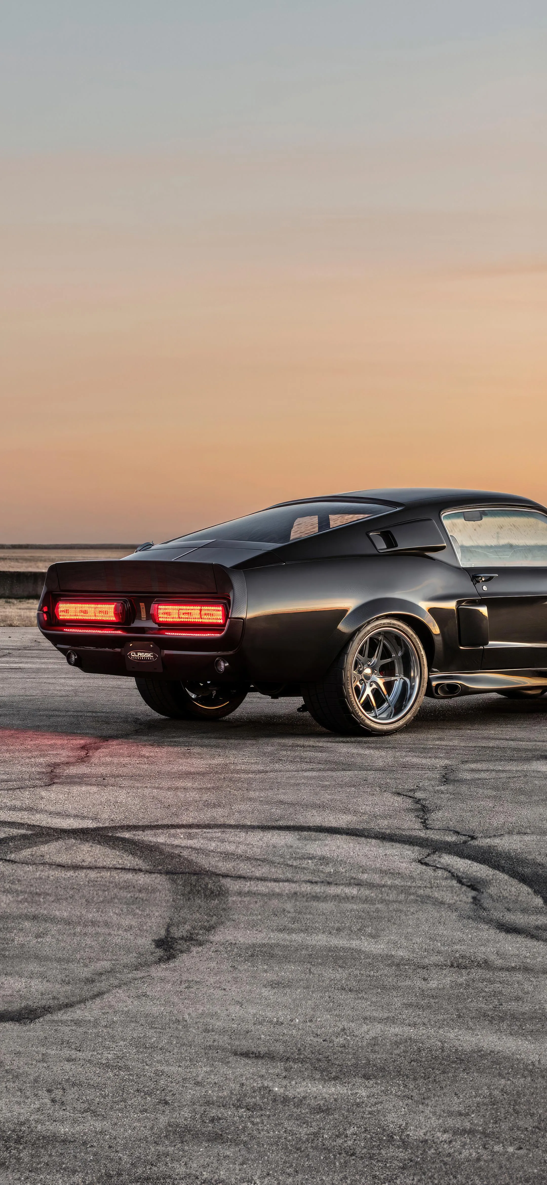 Muscle Car Driving into Sunset on Open Road Wallpaper