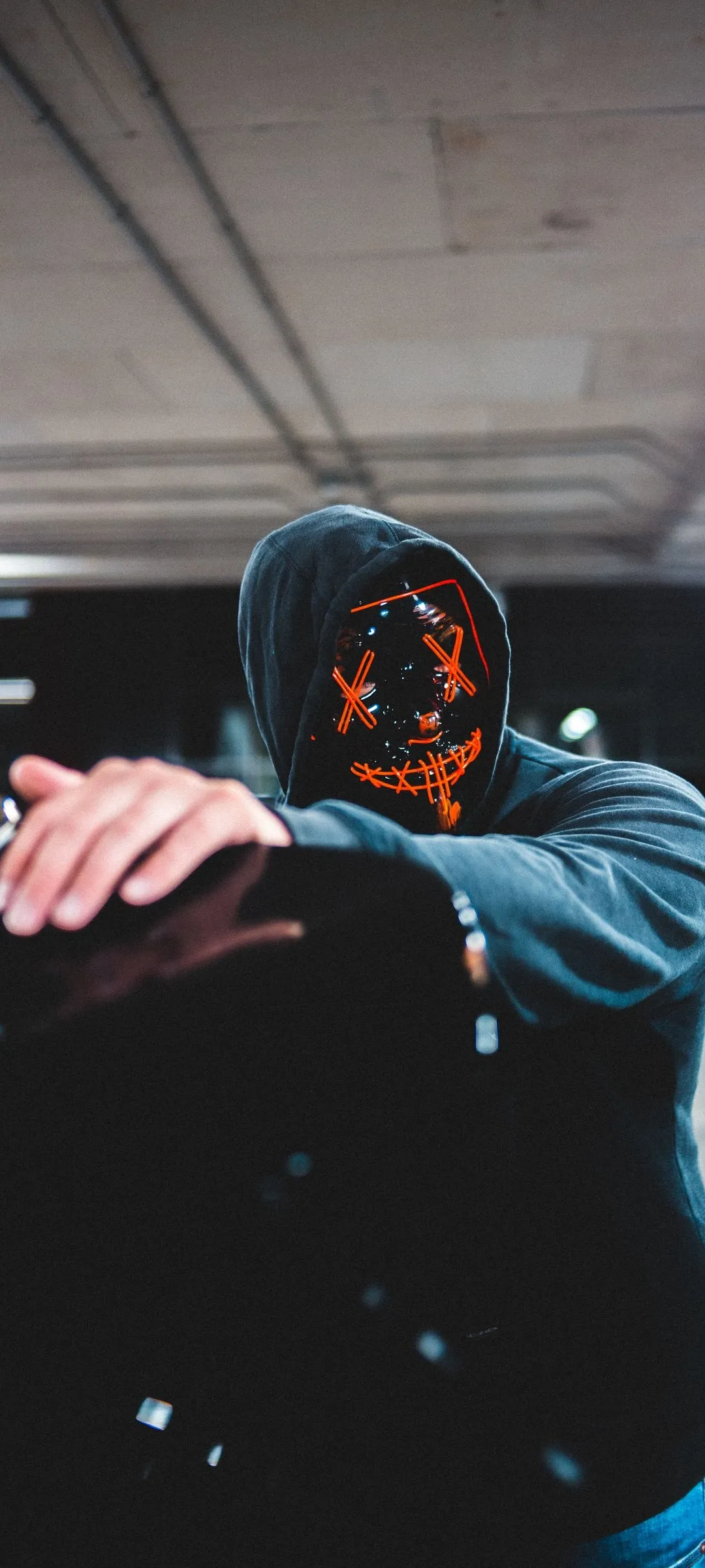 Mysterious Person Wearing Hoodie in Dark Setting with Mask
