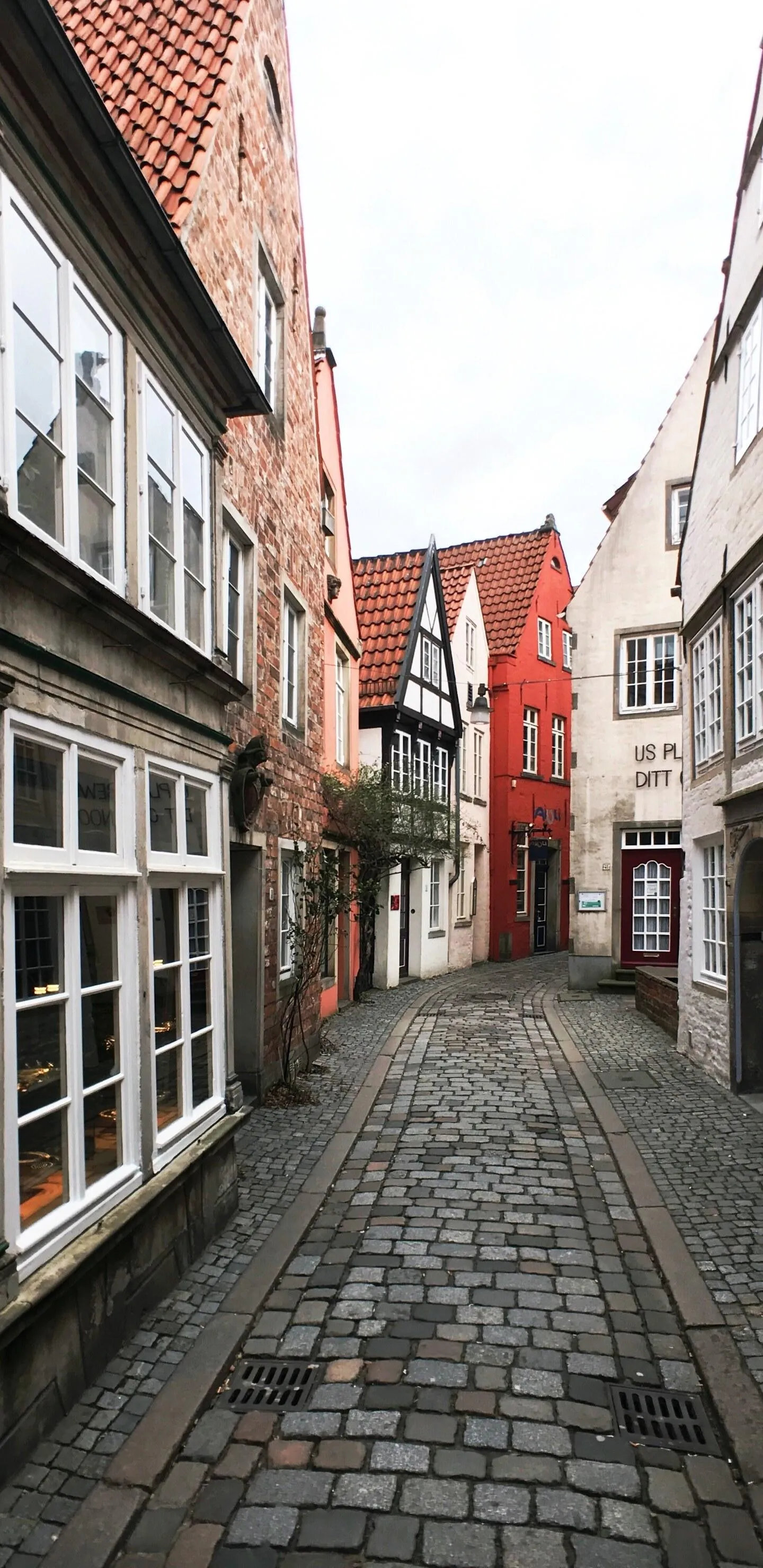 Narrow European Street with Old Buildings and Cobblestone Road
