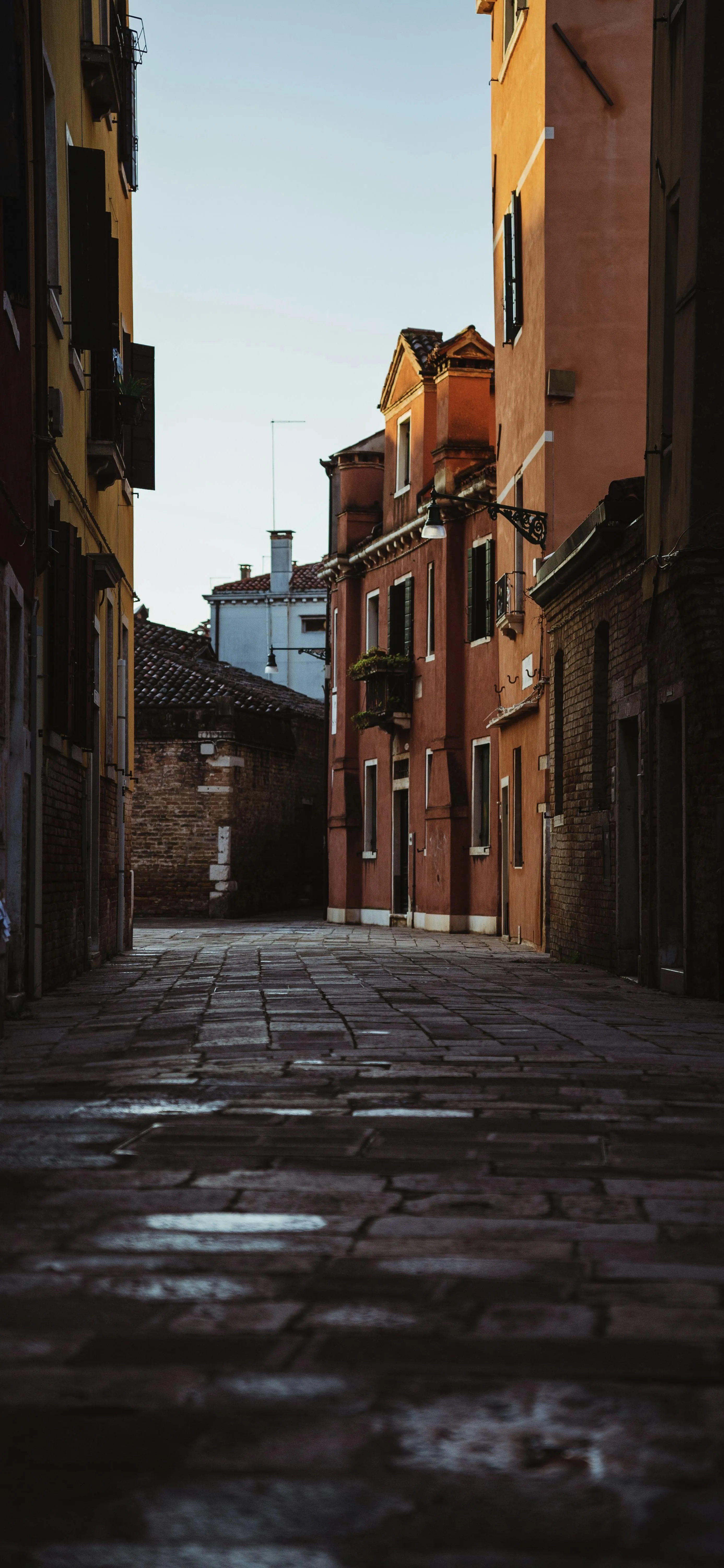 Narrow Street Between Tall Buildings in Golden Light