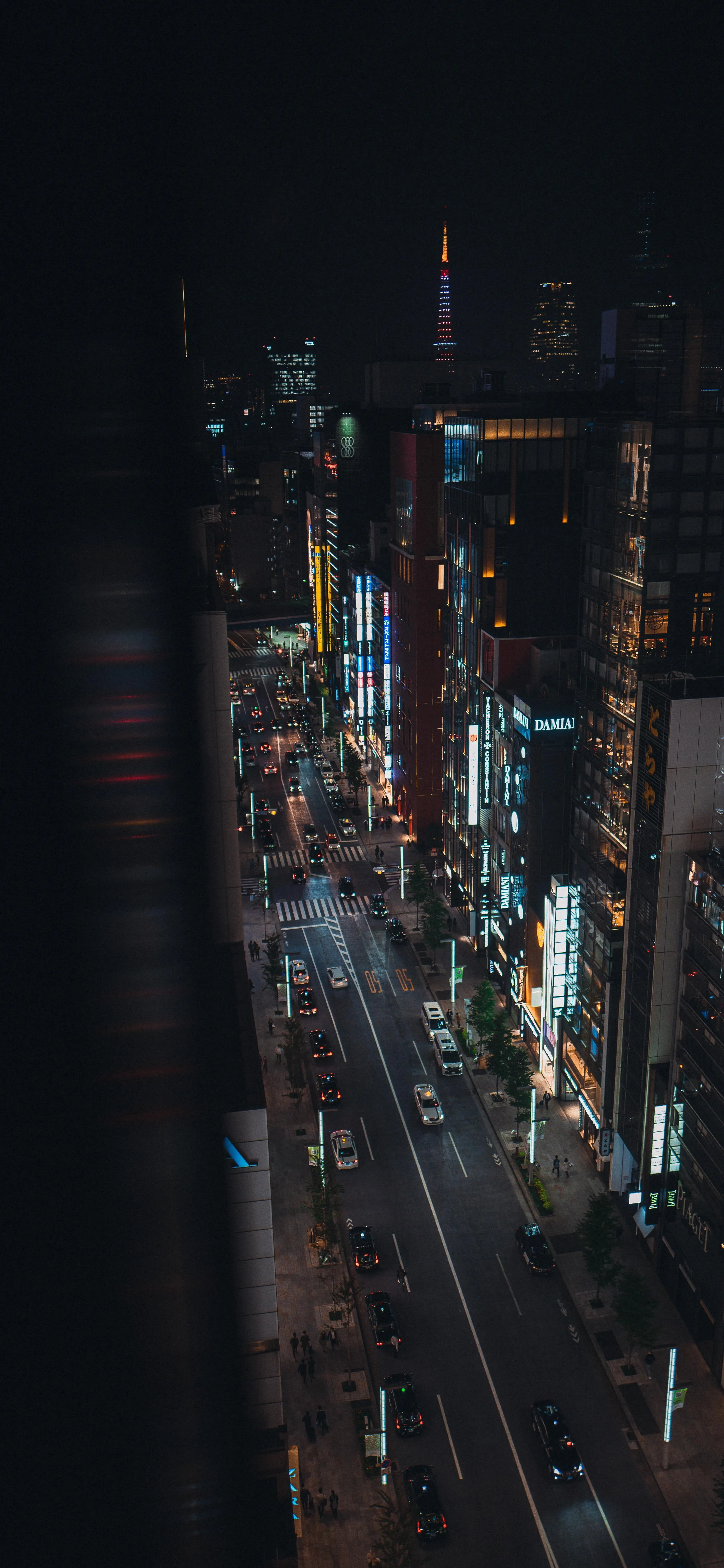 Night City Street Lit with Cars and Tall Urban Buildings