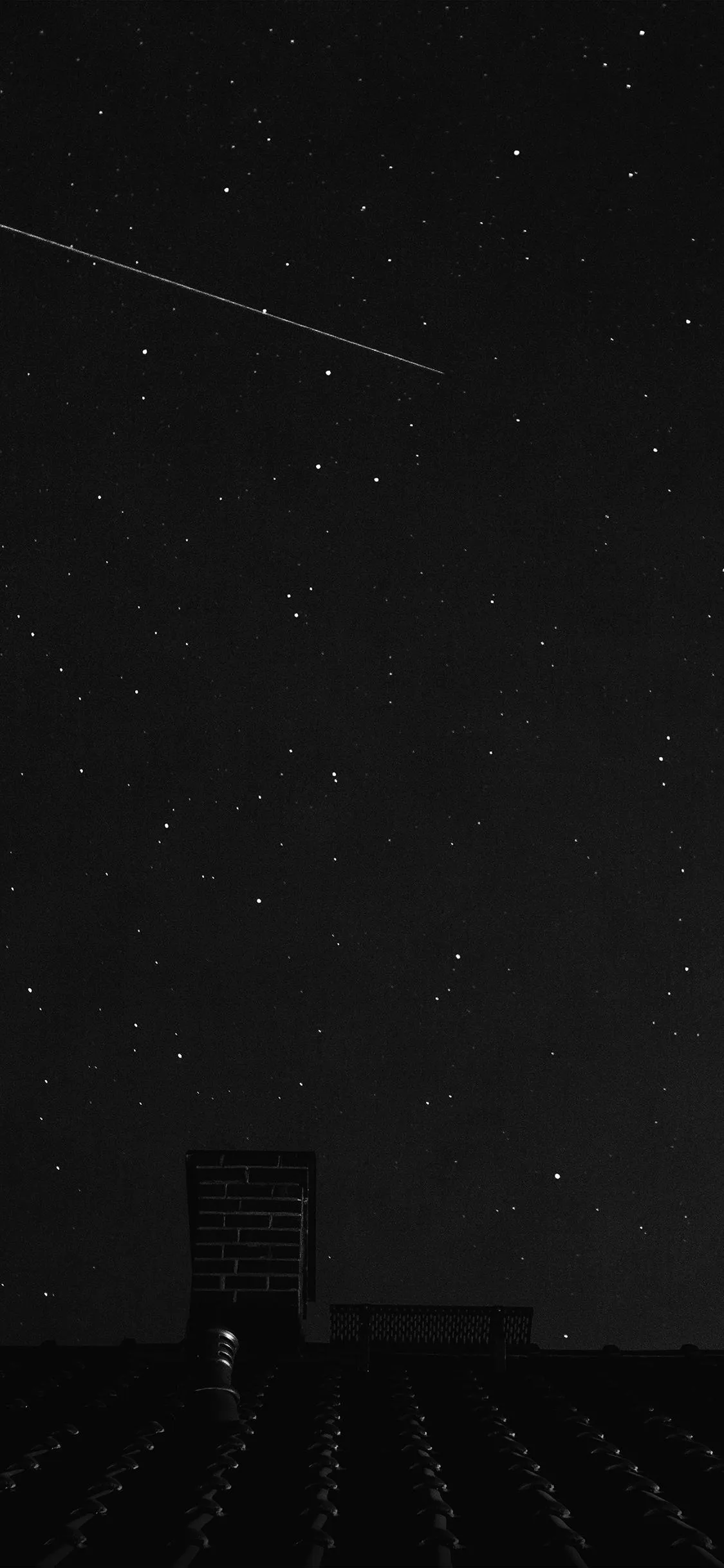 Night Sky with a Shooting Star over Quiet Roof Top Wallpaper