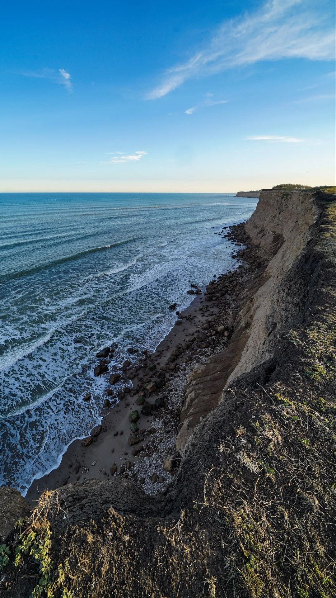 Ocean Shoreline with Waves under Clear Sky View Image