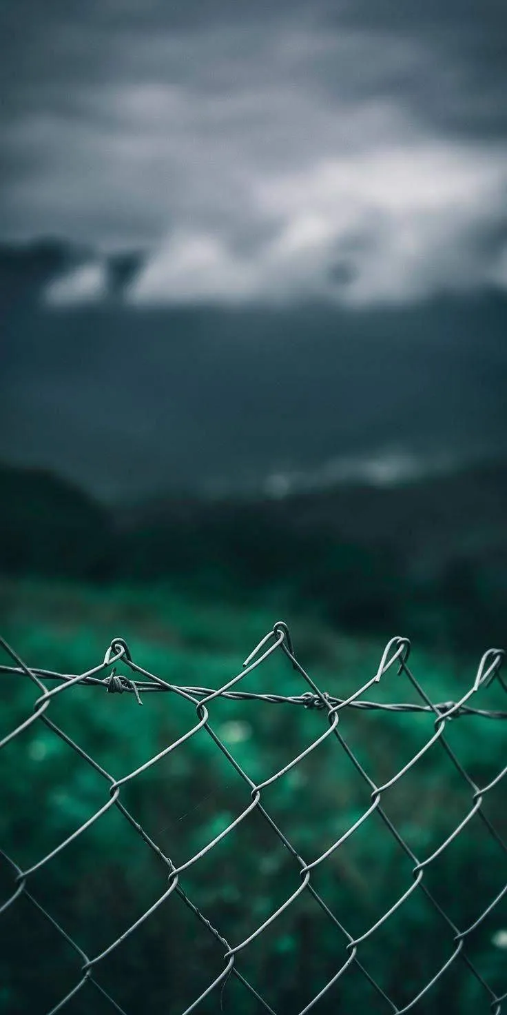 Ocean Waves Hitting Fence Under Moody Stormy Sky Scene