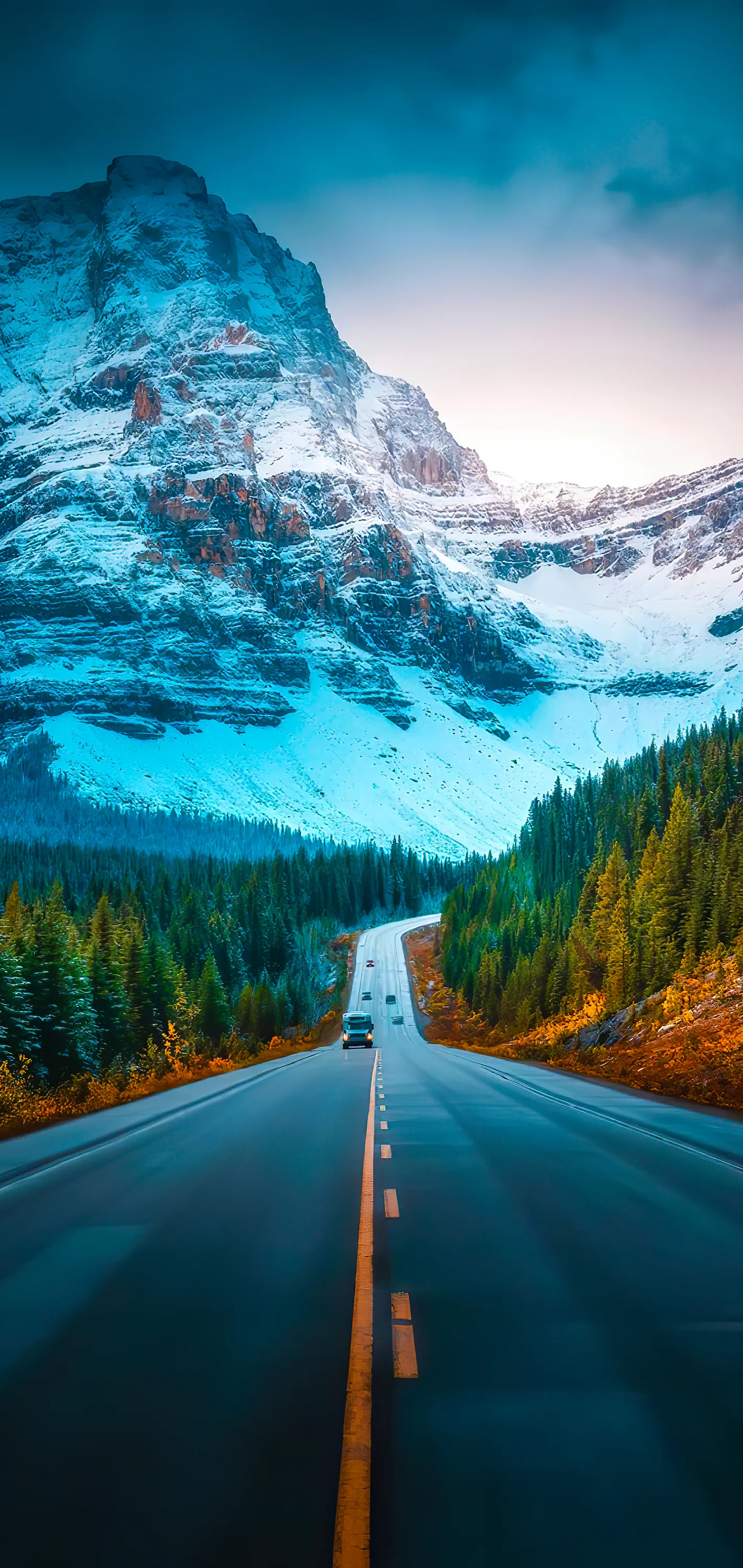 Open Road Leading To Snowy Mountains Under Clear Sky