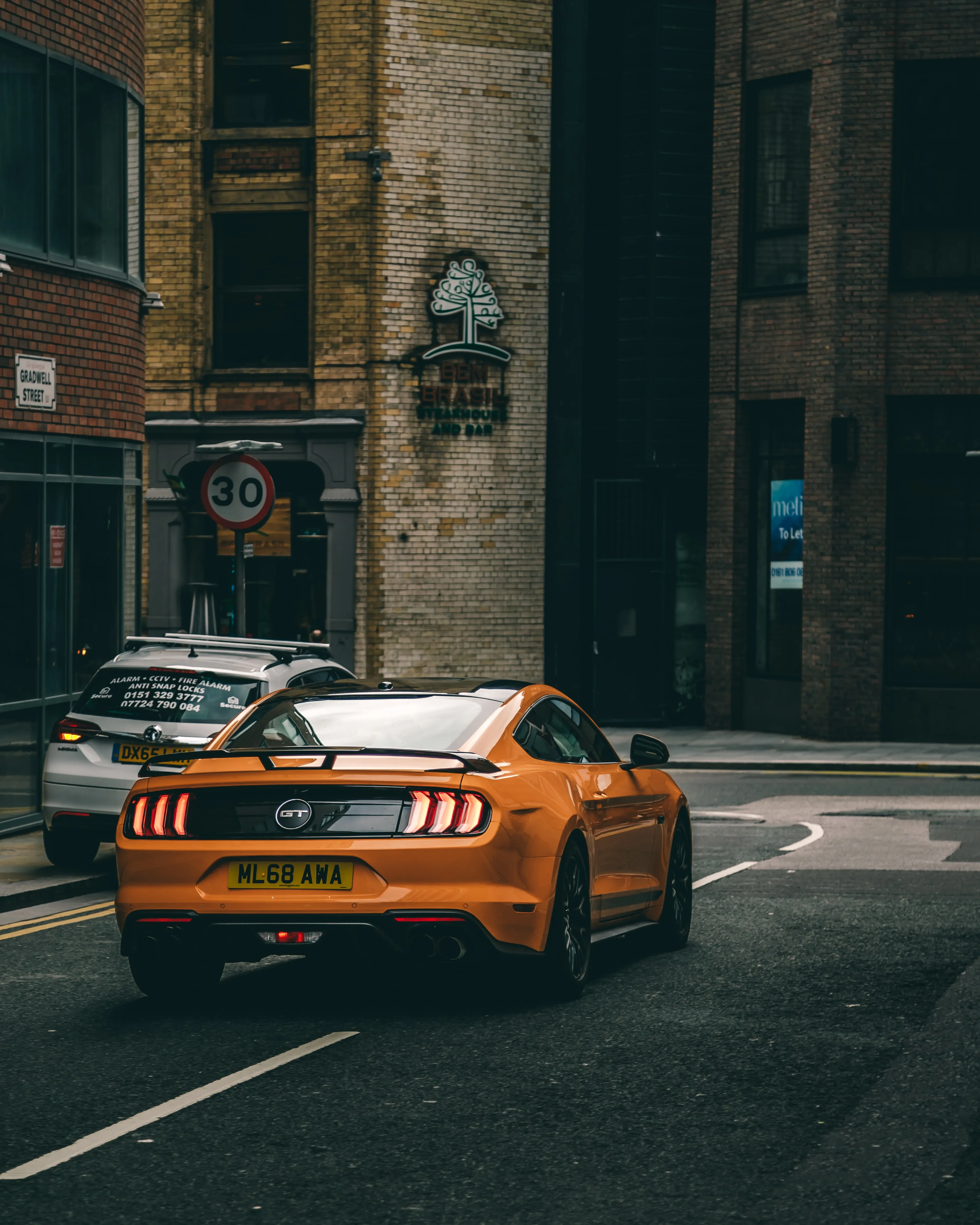 Orange Sports Car Parked in City Alleyway Wallpaper
