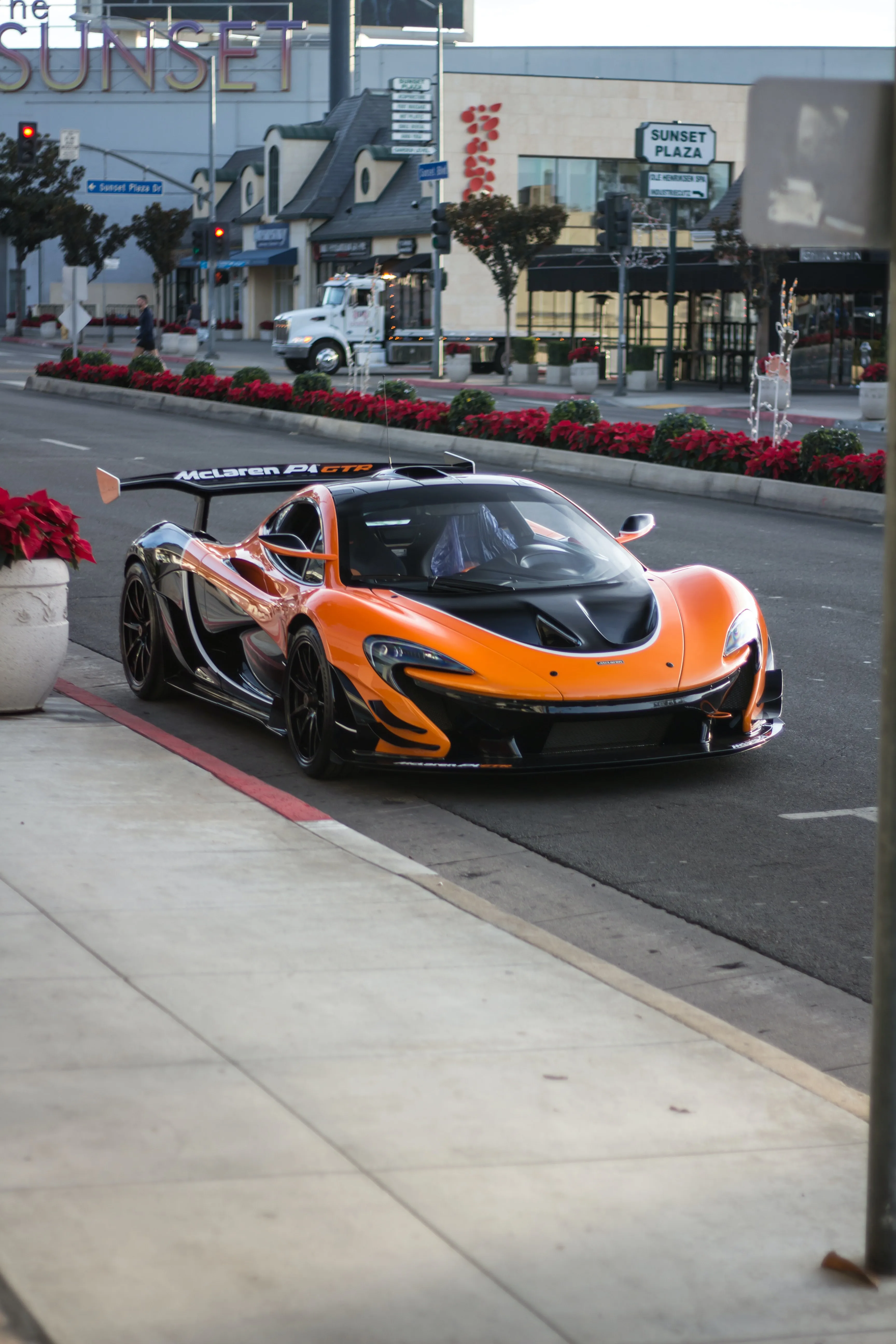 Orange Supercar on City Street with Urban Skyscraper View