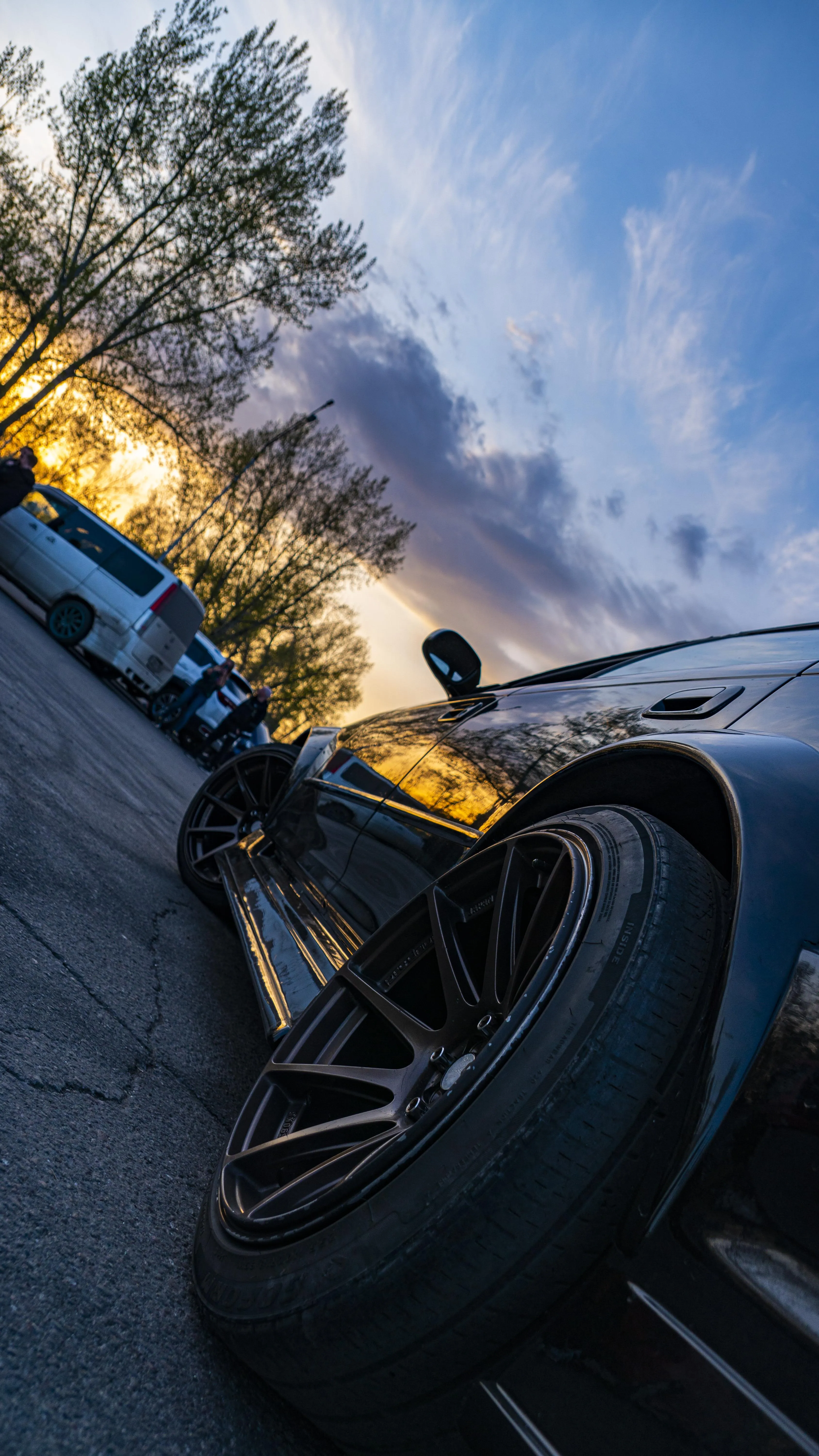 Parked Black Car with City Street Lights at Sunset Image