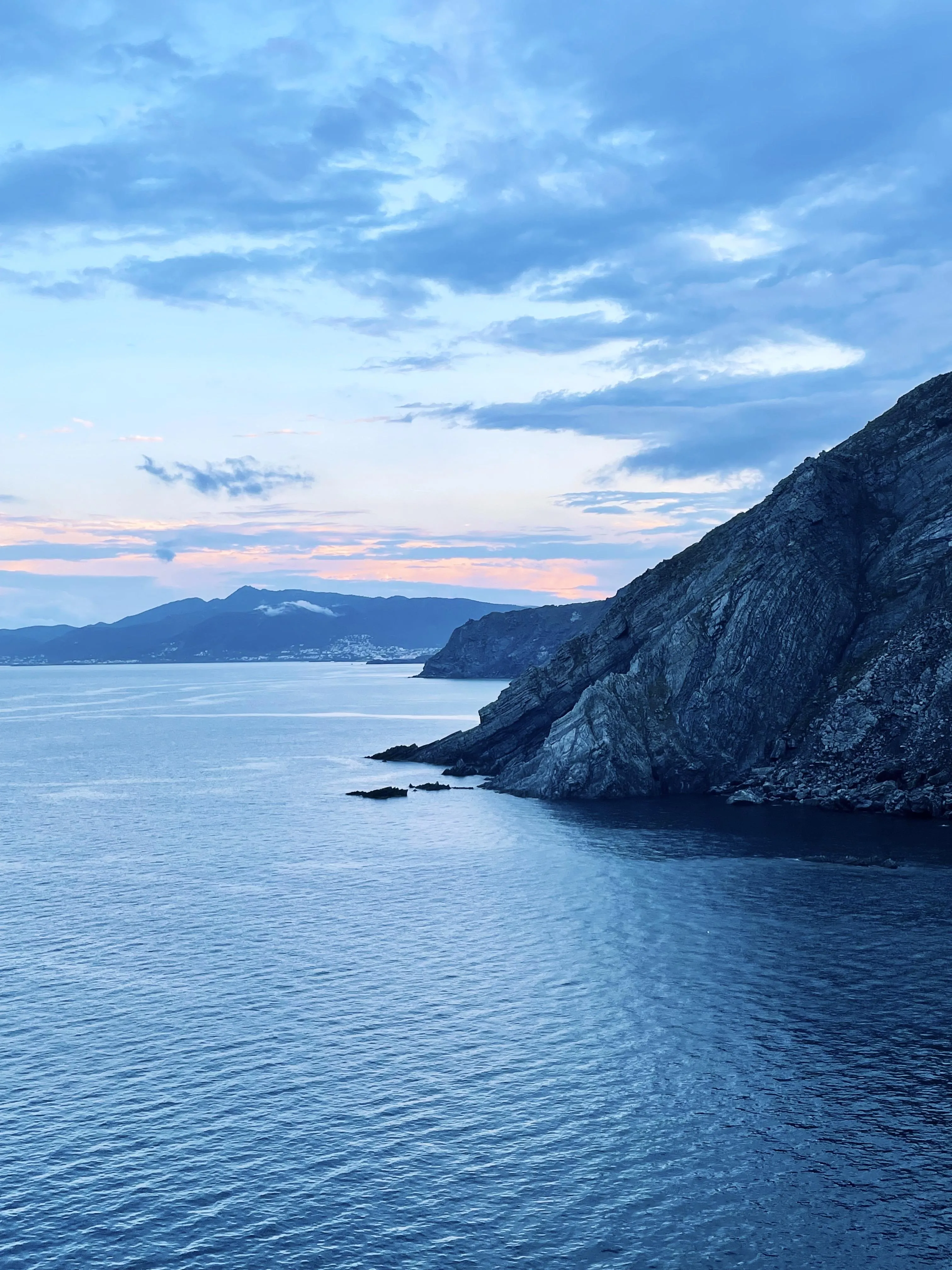 Peaceful Coastal Scene with Blue Sea and Rocky Cliffs Under Sky