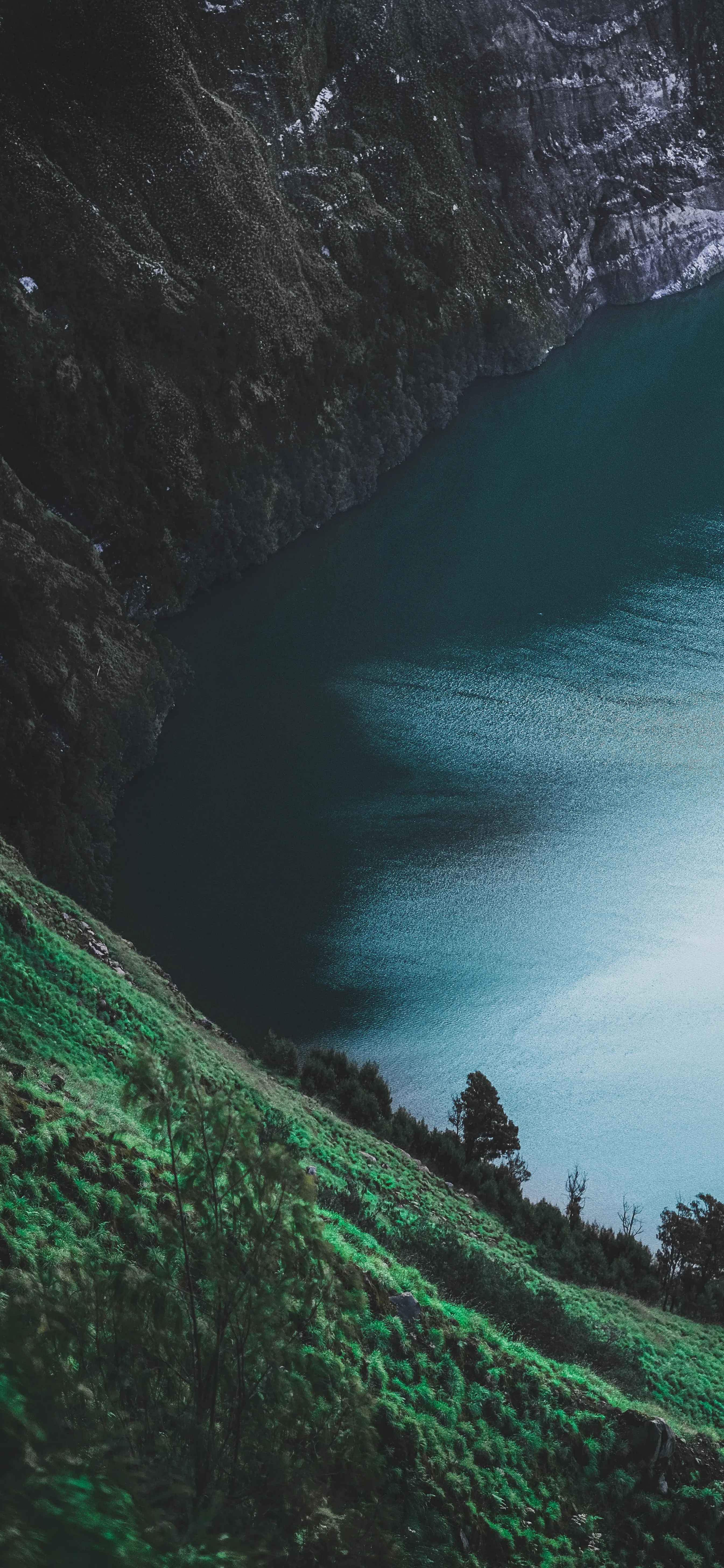 Peaceful Green Lake Between High Rocky Cliffs at Sunset