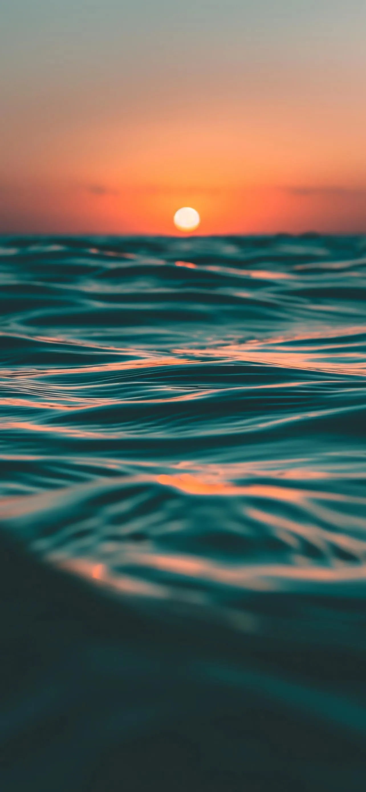 Peaceful Ocean Sunset with Orange Sky Reflections Wallpaper