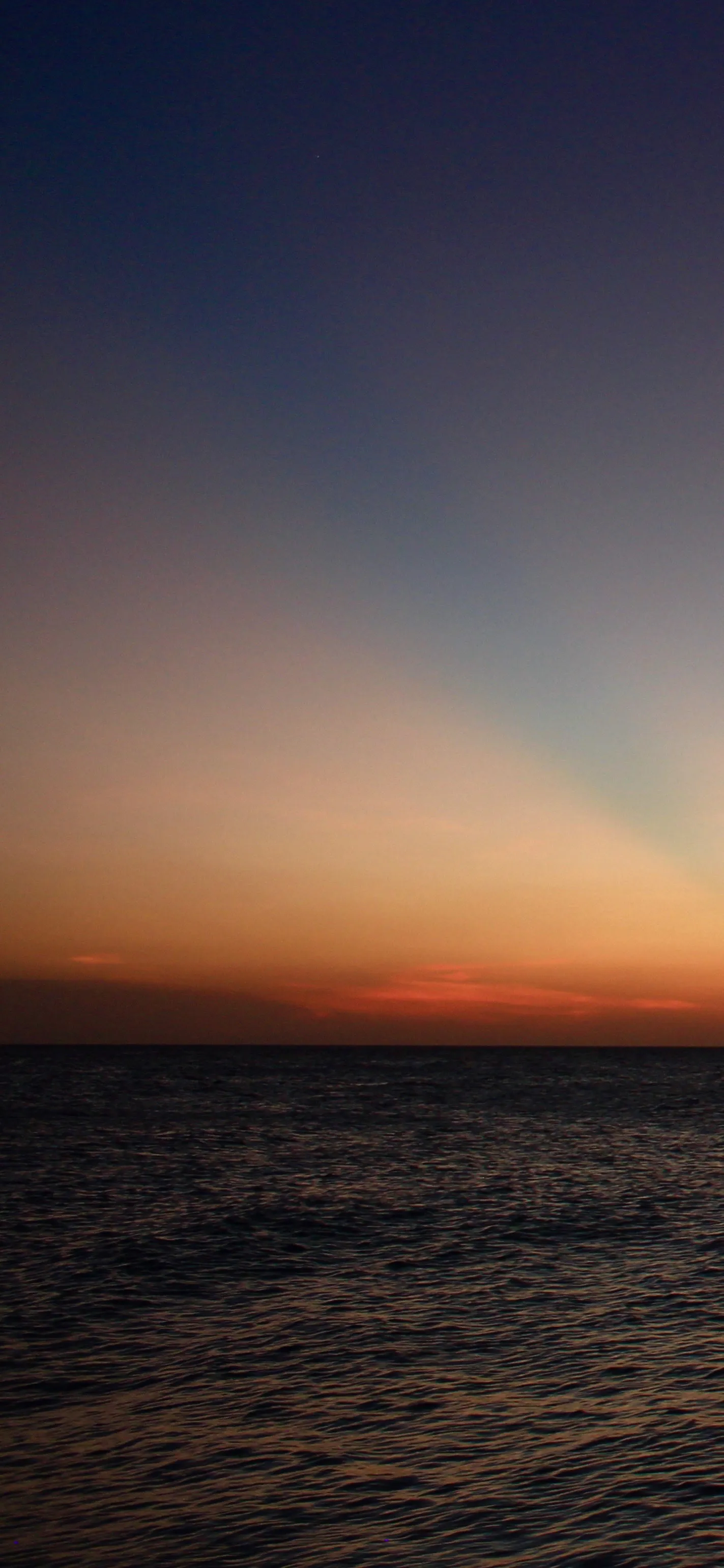 Peaceful Ocean Sunset with Warm Orange Light Glow Image