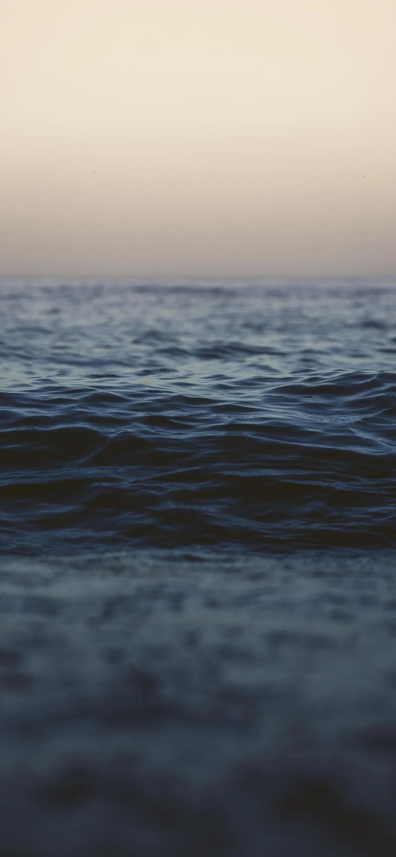 Peaceful Ocean Waves at Golden Sunset Horizon Wallpaper