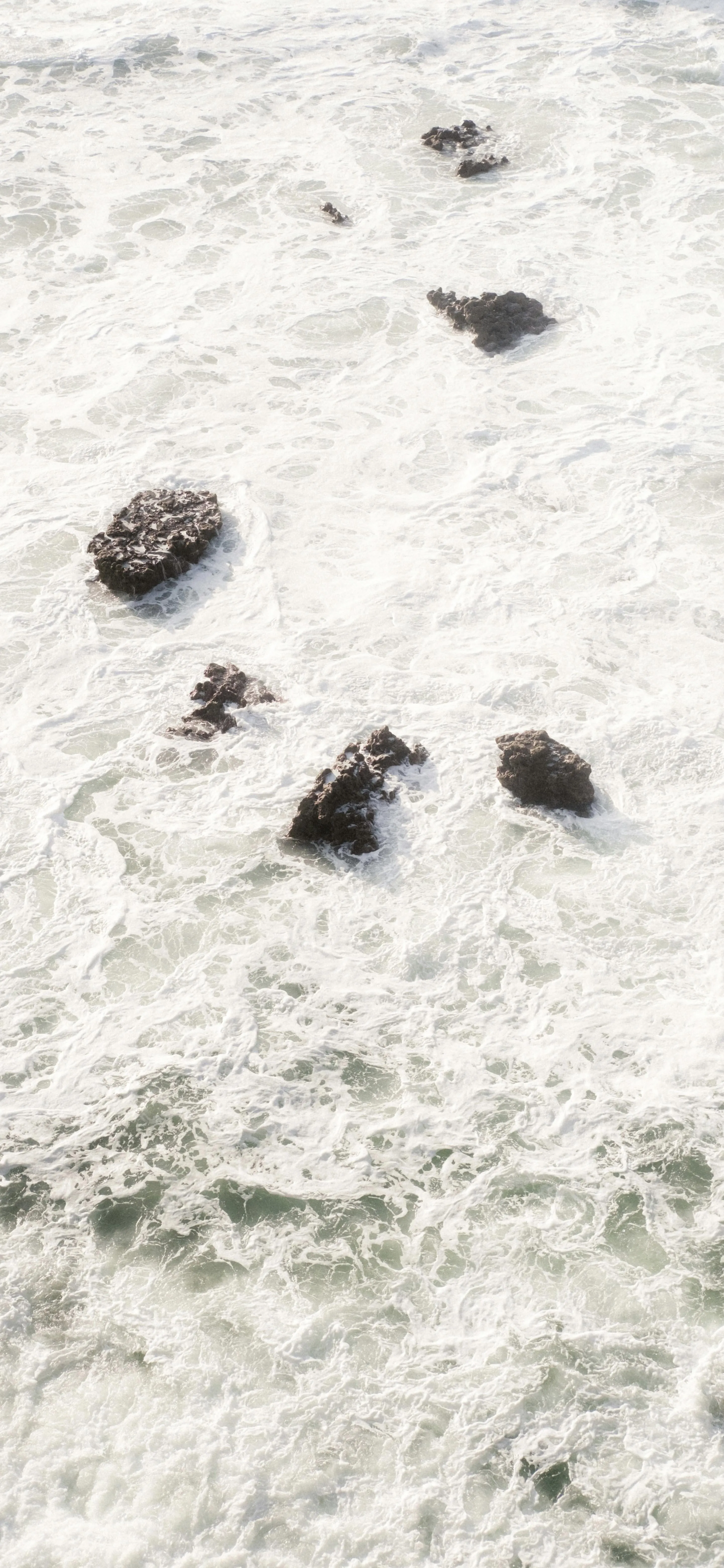 Peaceful Ocean Waves Surrounding Rocky Outcrops Image