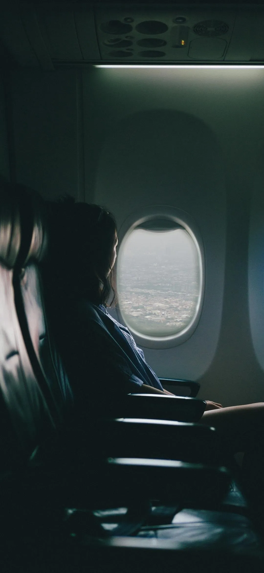 Peaceful traveler gazing through airplane window view