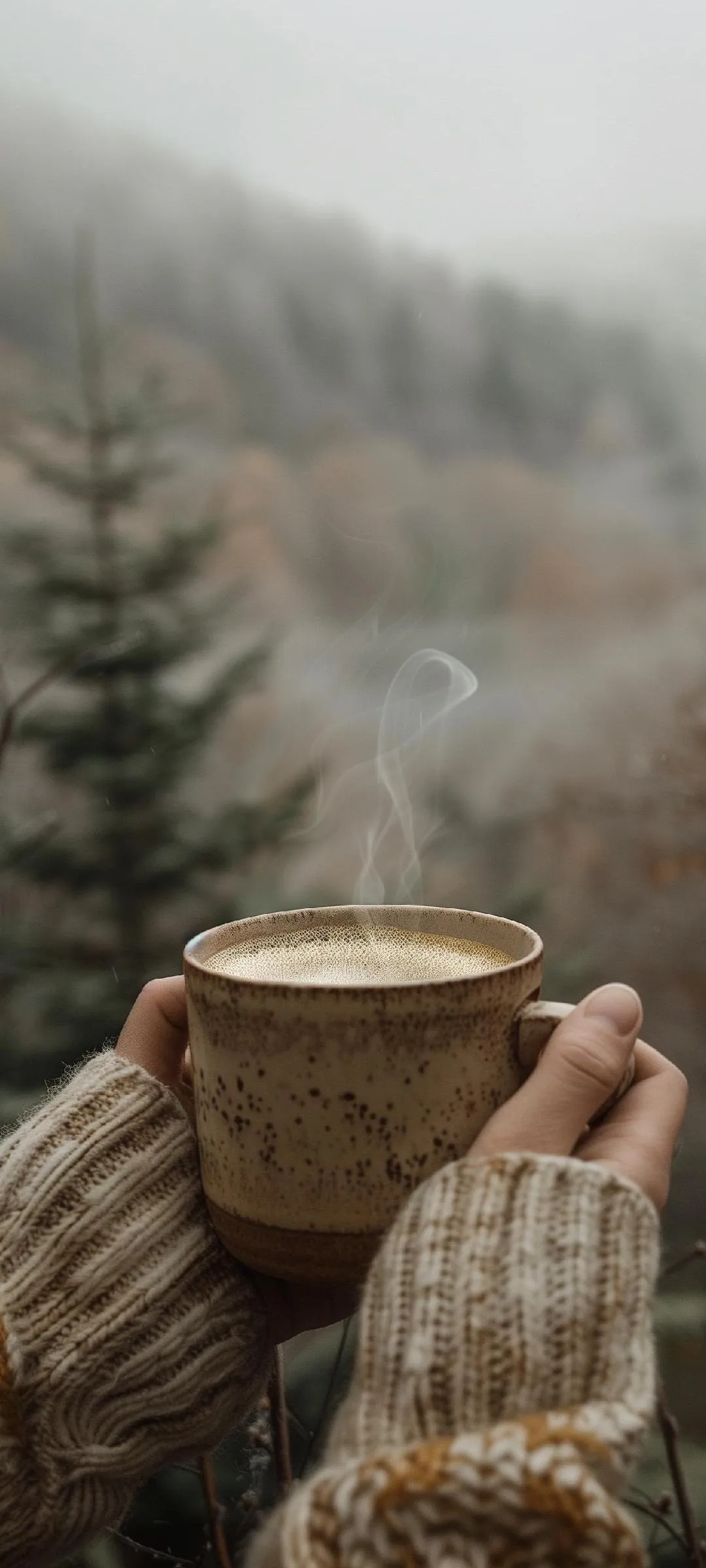 Person Holding Cup in Snowy Winter Forest Scene Wallpaper