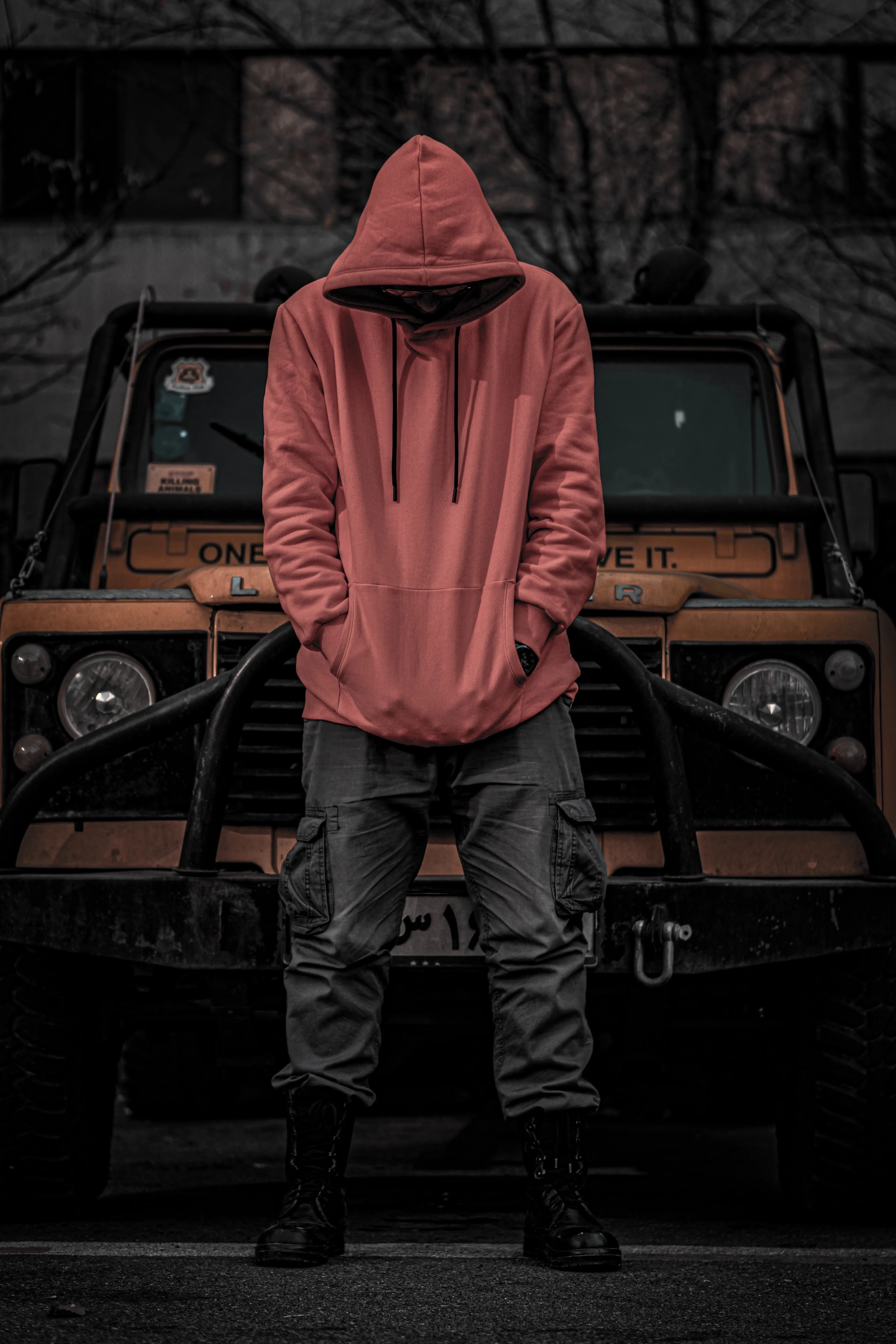 Person in Hoodie Standing Beside a Parked Car Wallpaper