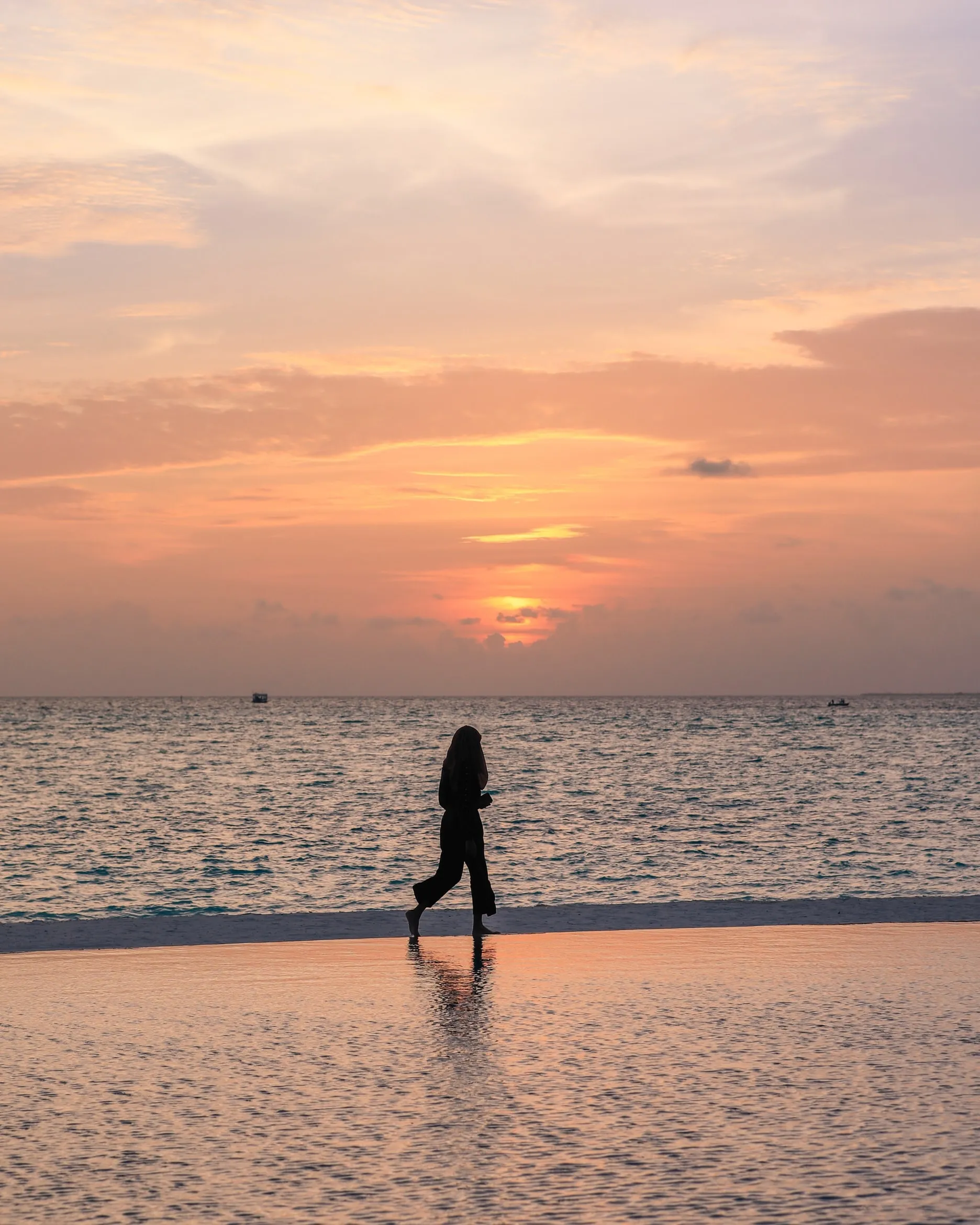 Person Walking on Beach at Golden Hour Sunset Wallpaper