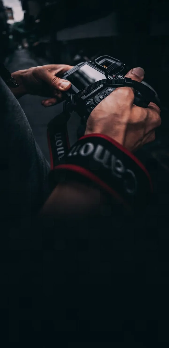 Photographer Adjusting Canon Camera Settings Wallpaper