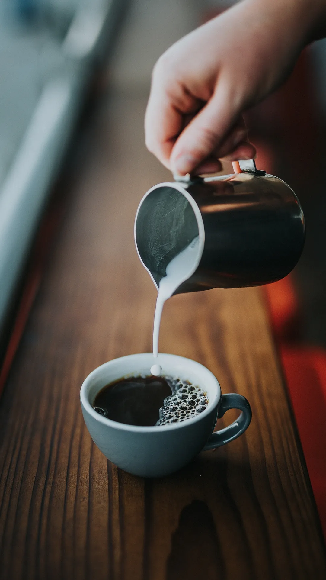 Pouring Fresh Coffee into Cup on Wooden Table Top Image
