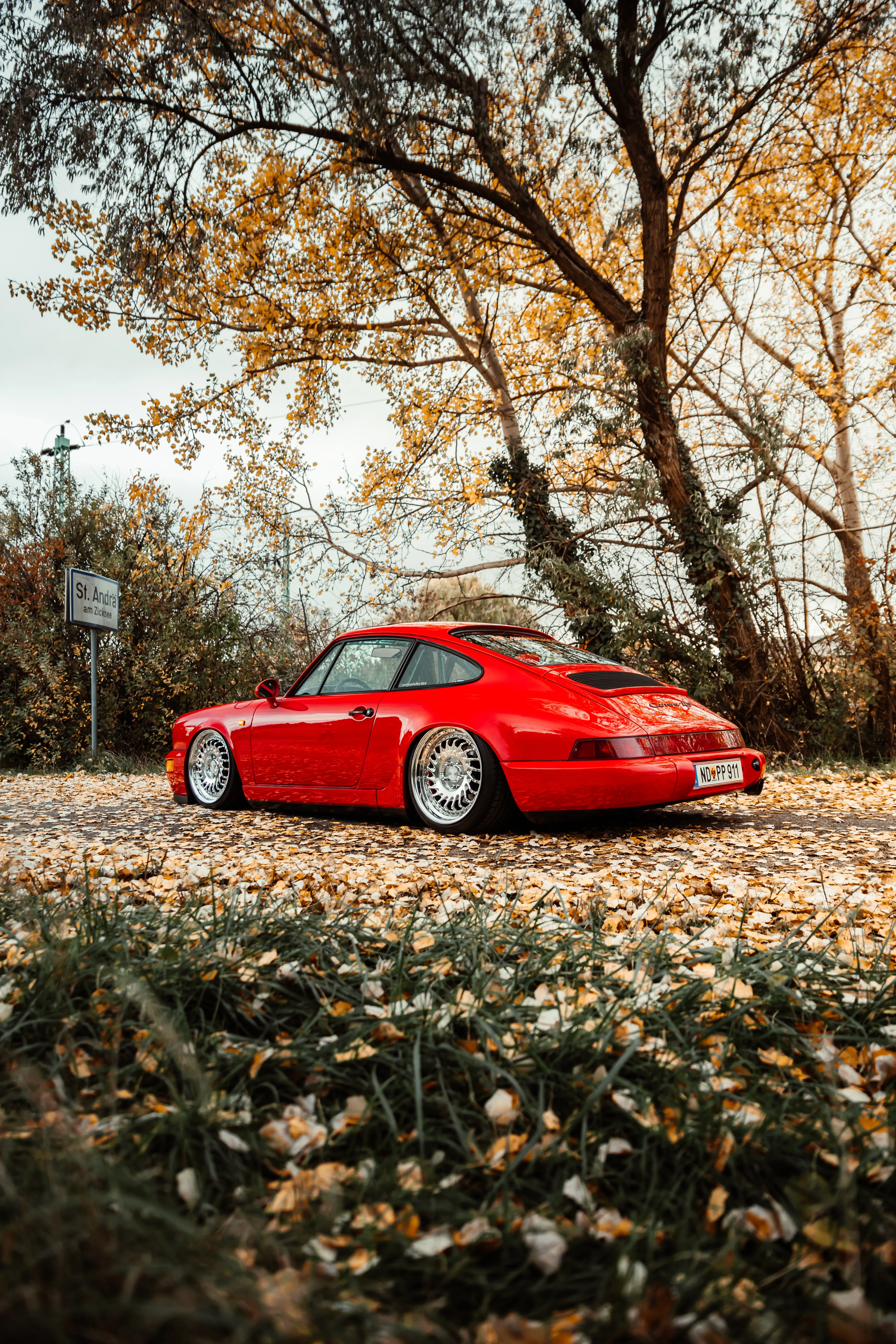 Red Classic Car Parked in Autumn Woodland Wallpaper