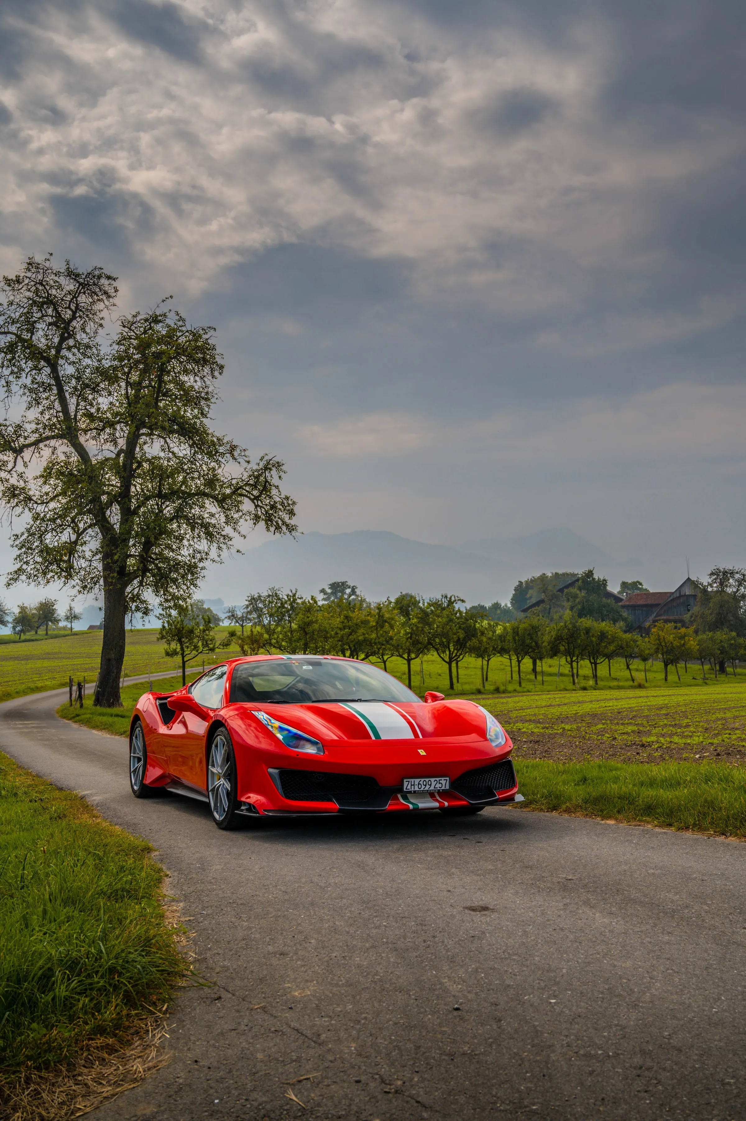 Red Sports Car Driving on Countryside Green Road Image