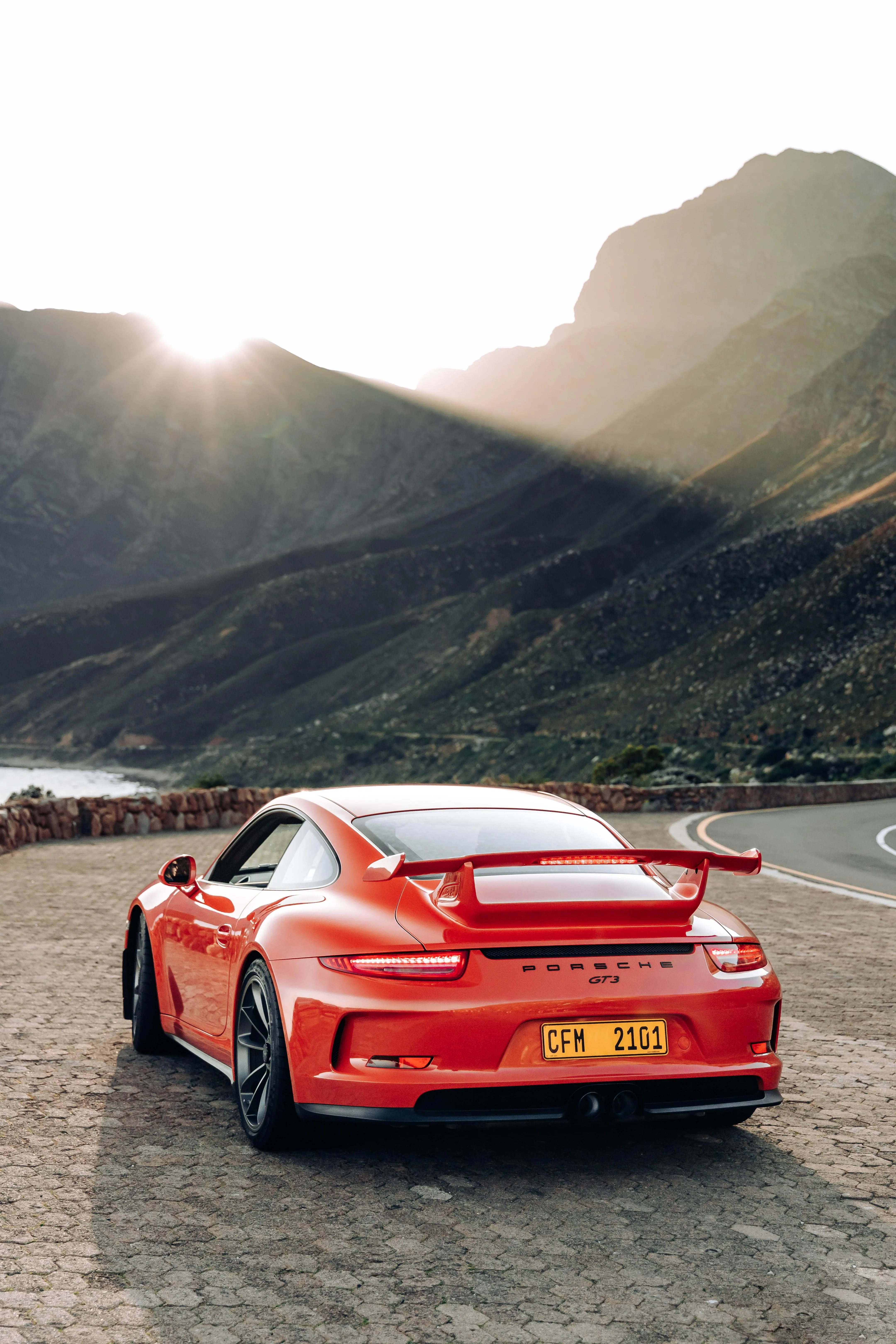 Red Sports Car Driving on Scenic Mountain Road Wallpaper