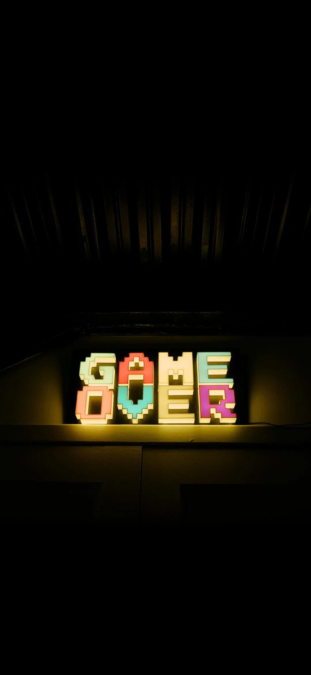 Retro Neon Game Over Text Glowing on Black Screen Wallpaper