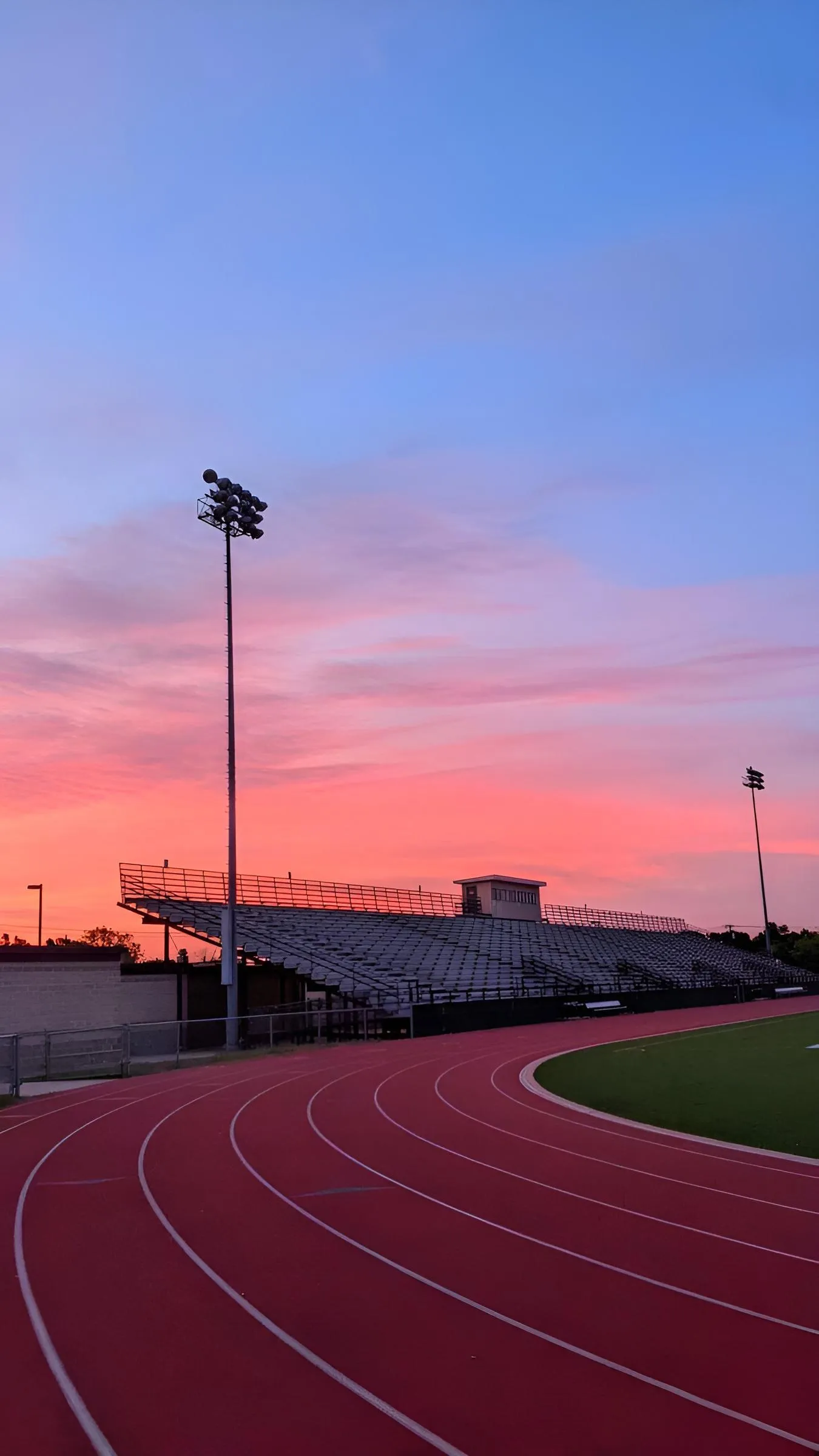 Running Track at Sunset with Street Lights Glow Wallpaper