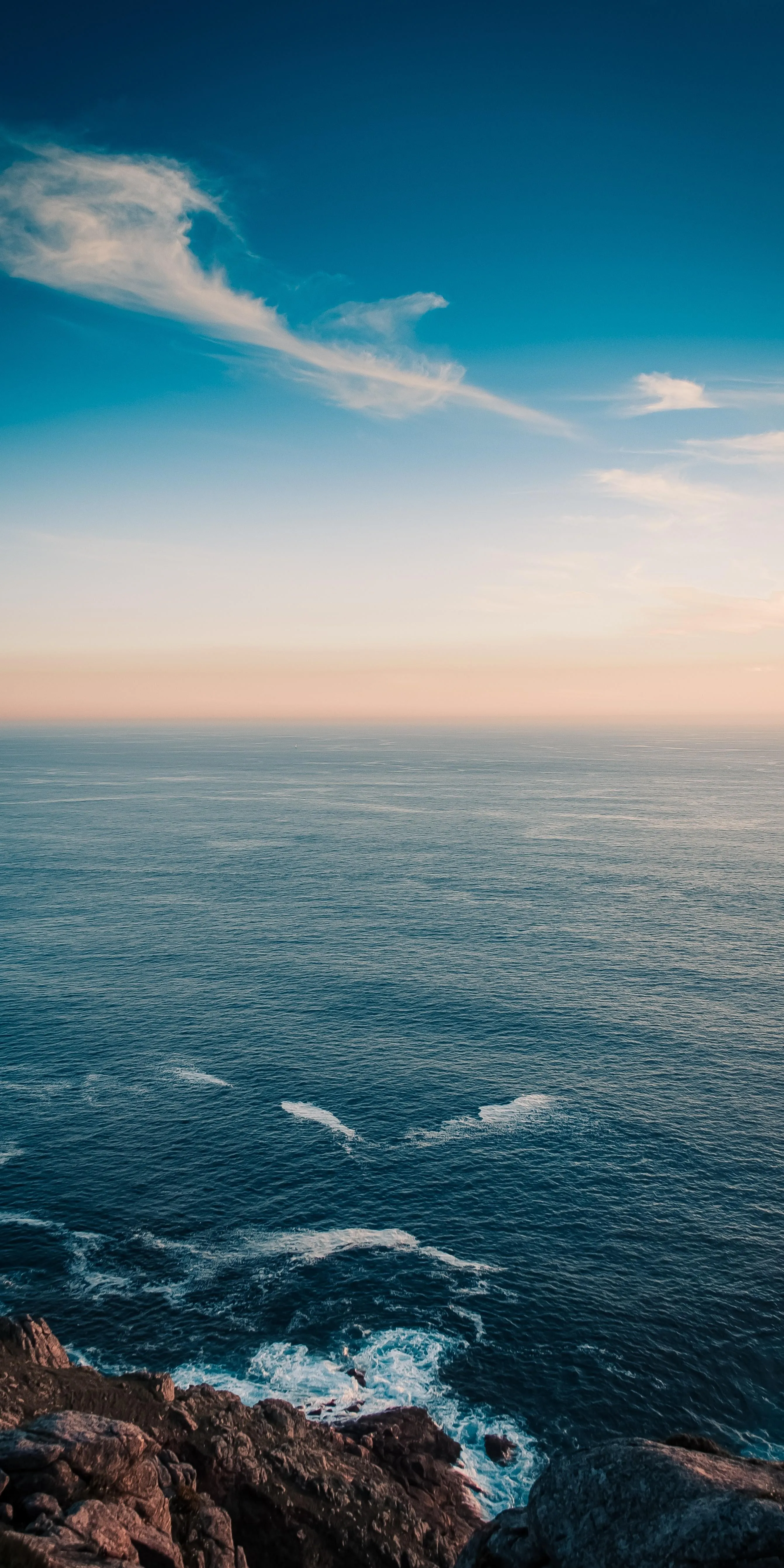 Scenic Ocean View with Rocky Shore and Blue Sky Image