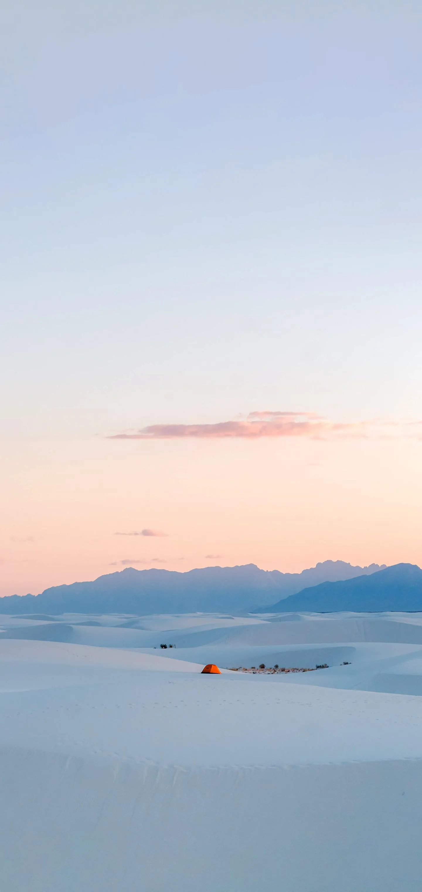 Serene desert camping at dawn over white sand dunes